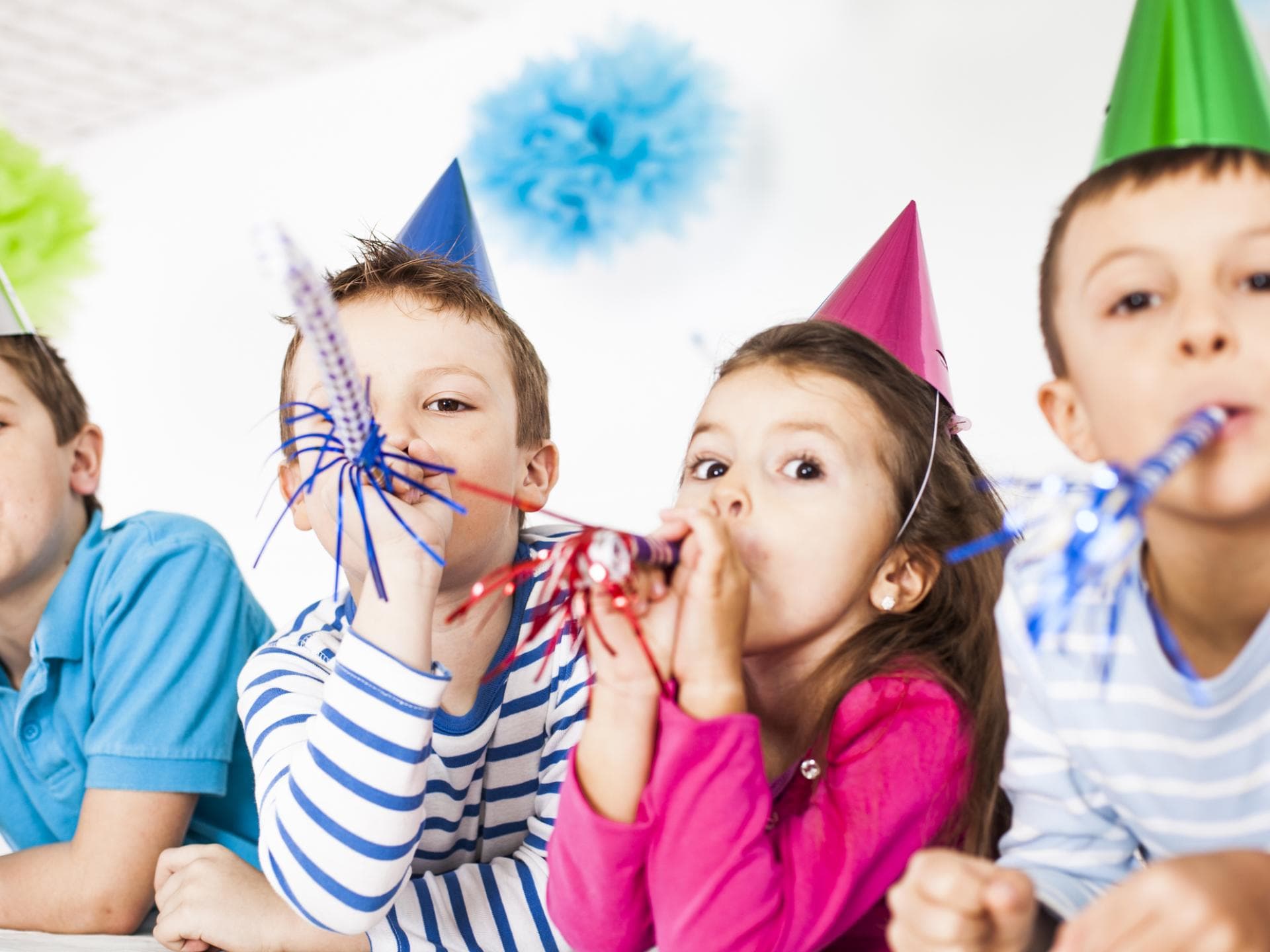 Kinder mit Partyhüten und Tröten.
