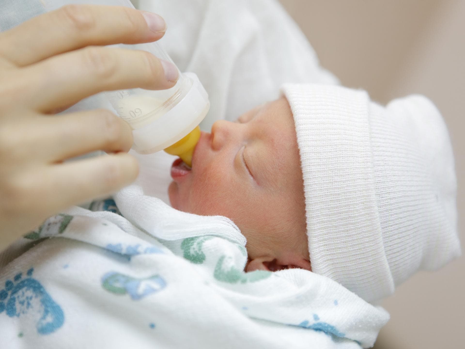 Stuhlproben in der Muttermilch sollen nach einem Kaiserschnitt helfen Ein Säugling, der aus der Flasche trinkt