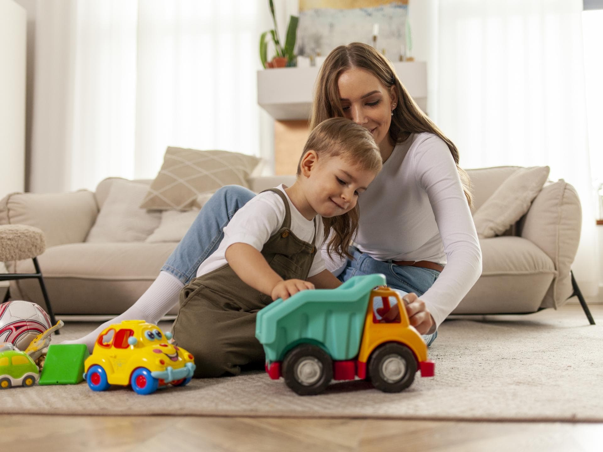 Jungs-Mamas müssen sich oft ungebetene Kommentare anhören. Mutter spielt mit ihrem Sohn auf dem Fußboden.