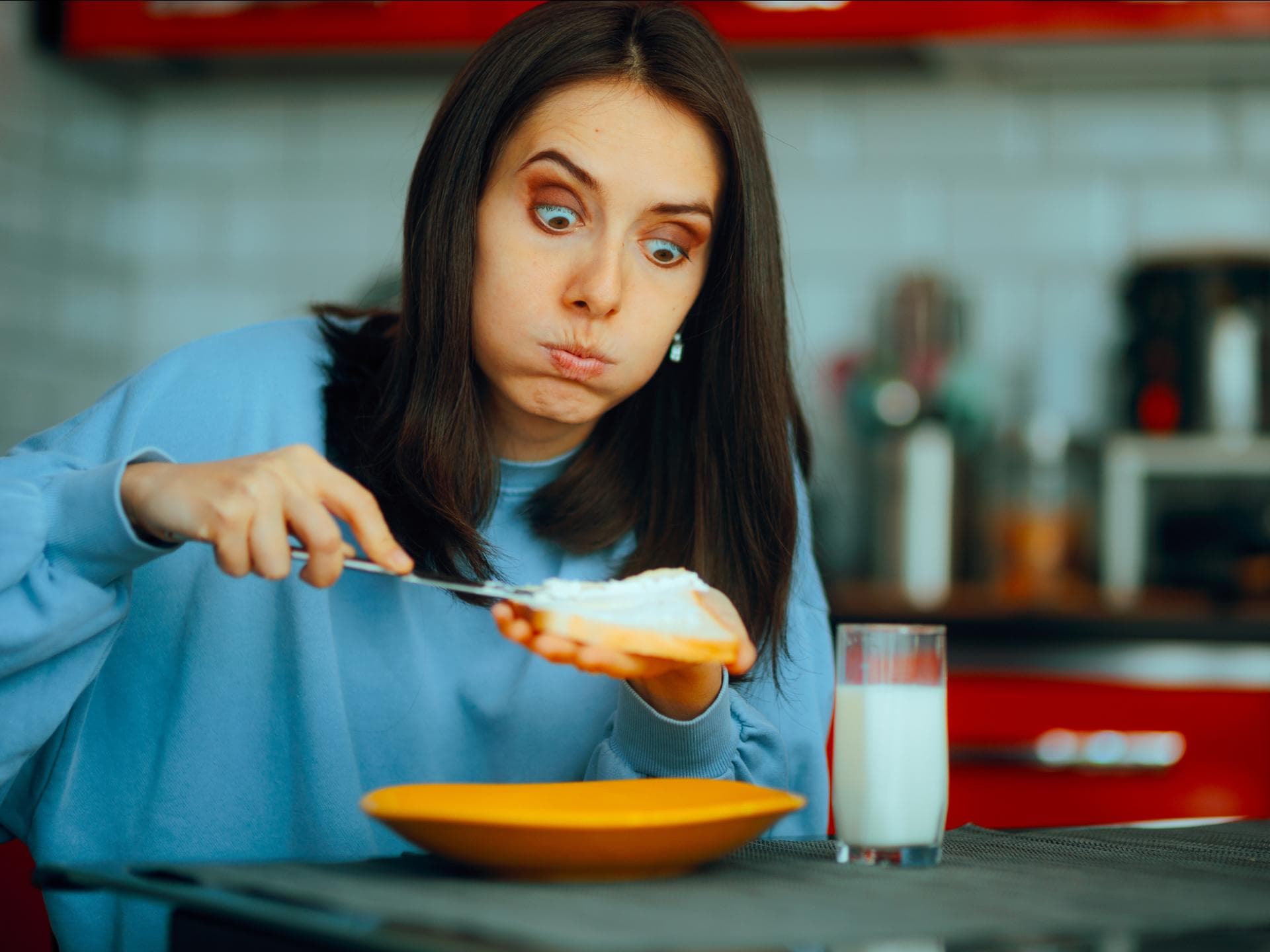Frau schmiert sich Ricotta aufs Brot.