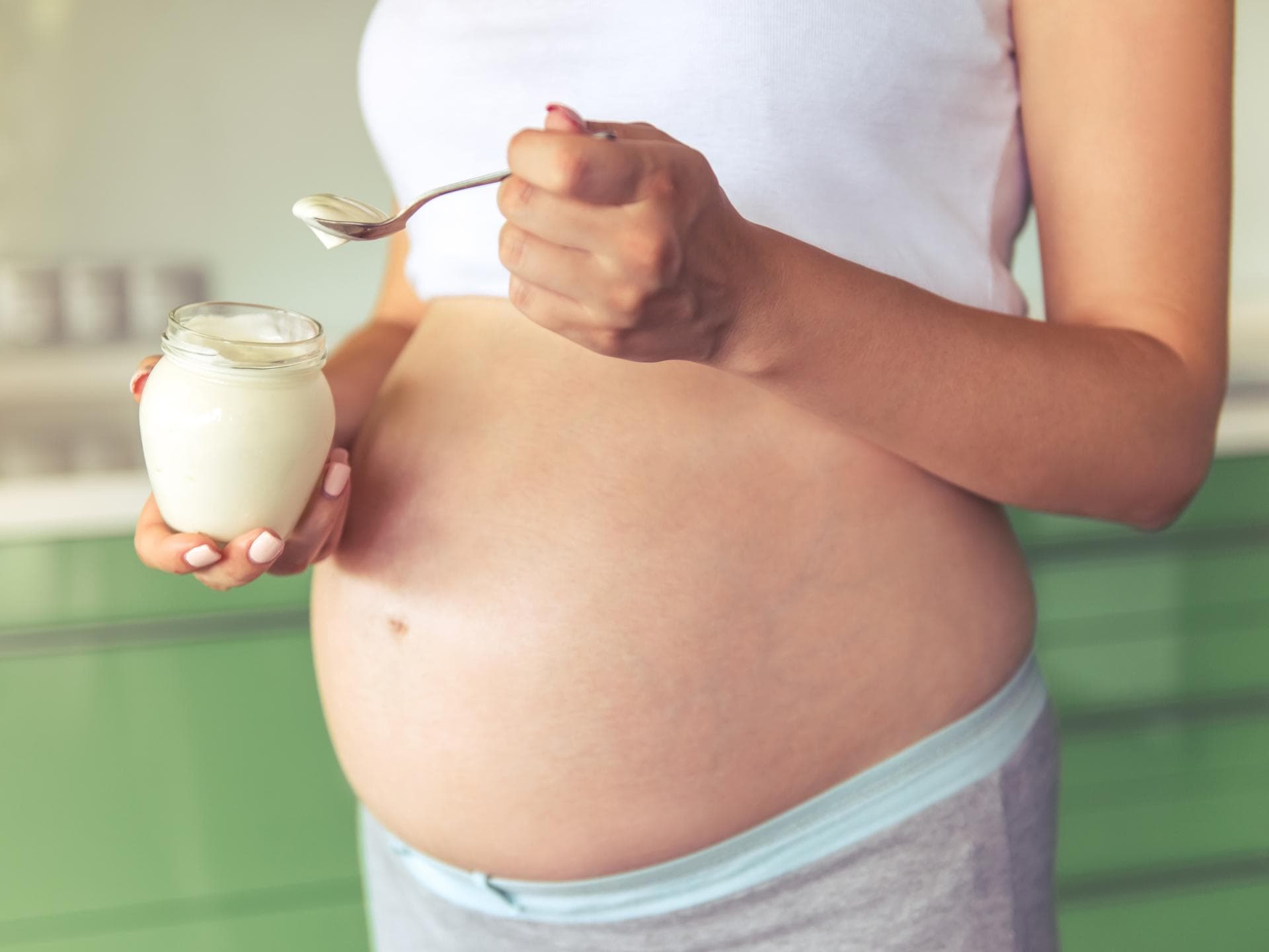 Panna Cotta in der Schwangerschaft ist normalerweise kein Problem. Schwangere Frau isst Panna Cotta.