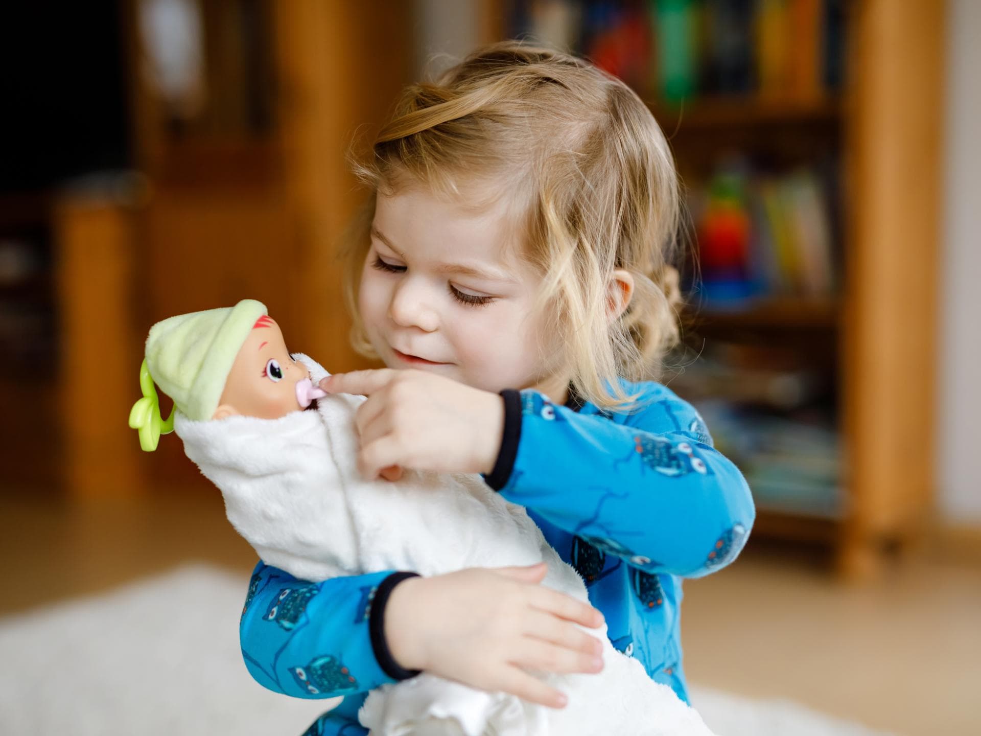 Ein Mädchen spielt mit einer Puppe. 