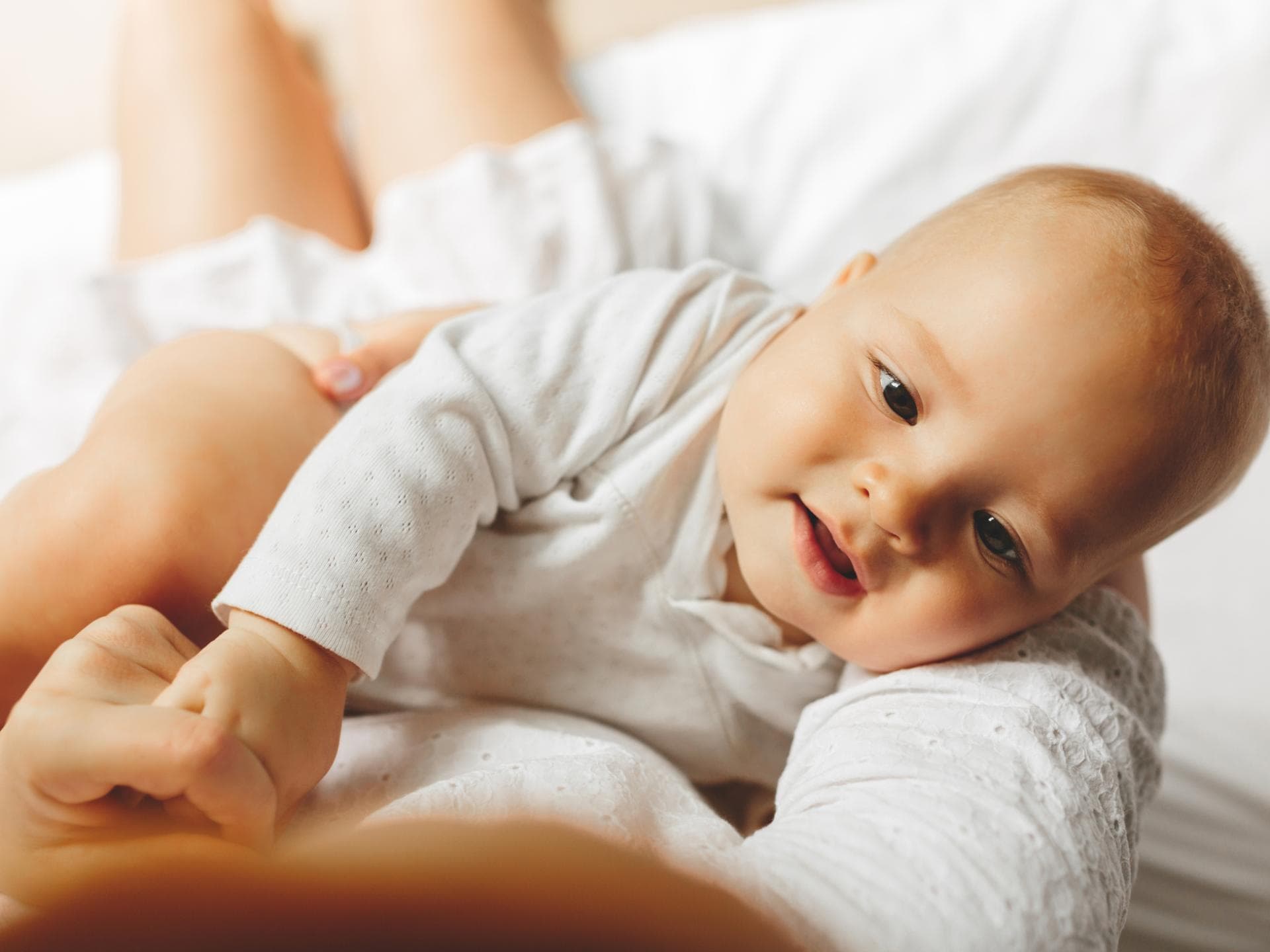 Bei den Babynamen 2024 gab es einige Veränderungen. Baby liegt im Arm der Mutter.