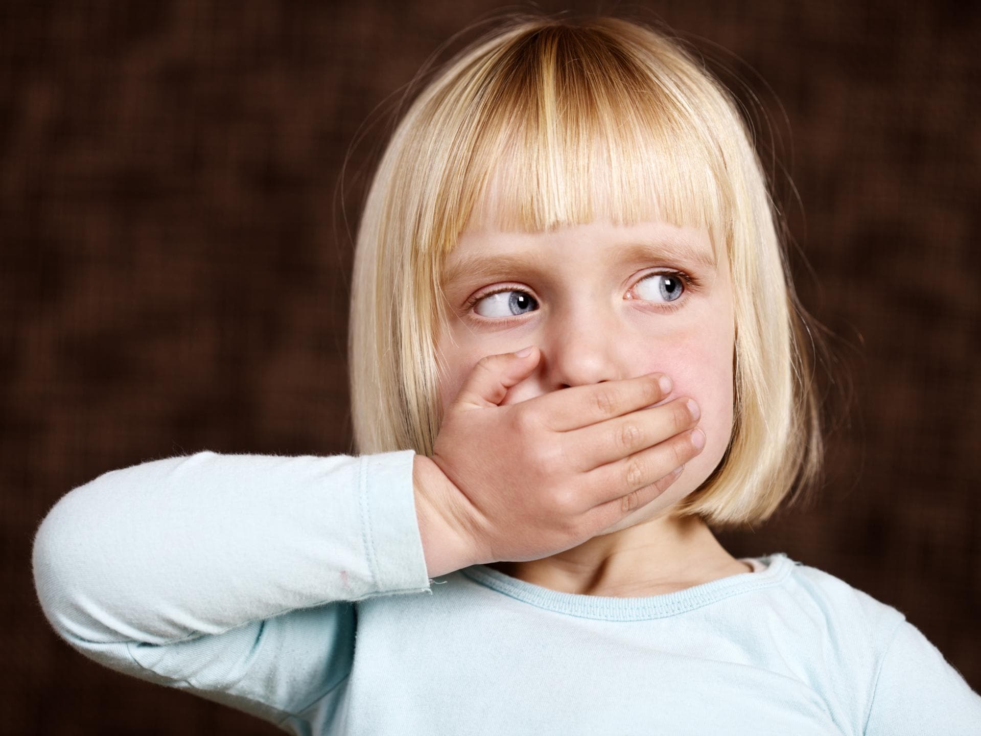 Beim Oma-Handtaschen-Syndrom sind Medikamente für Kinder frei zugänglich. Kind hält sich die Hand vor den Mund.