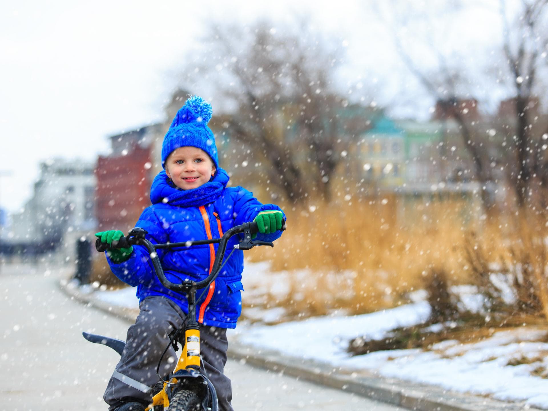 Kind fährt im Schnee Fahrrad.