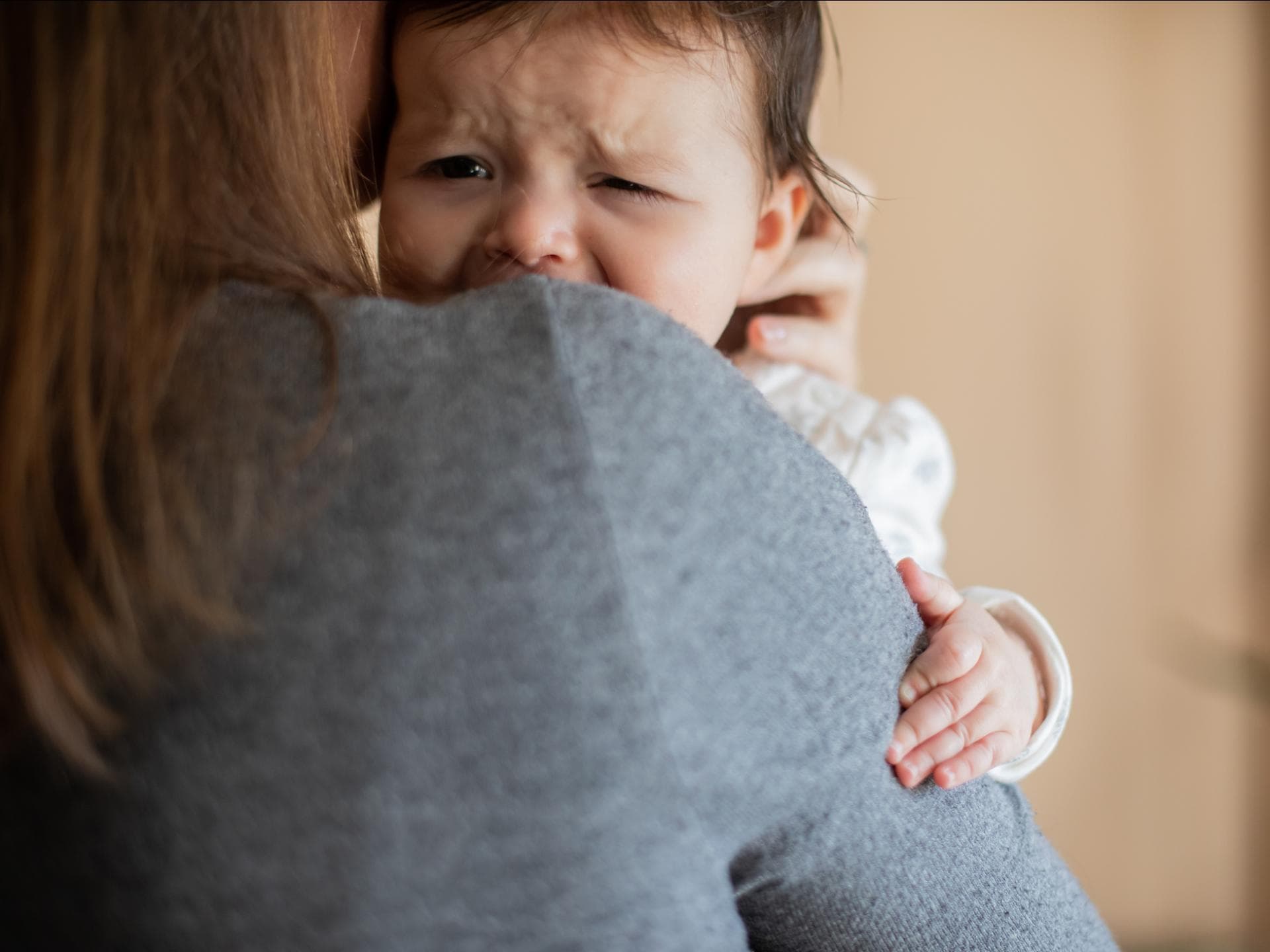 Baby weint auf Mamas Arm.