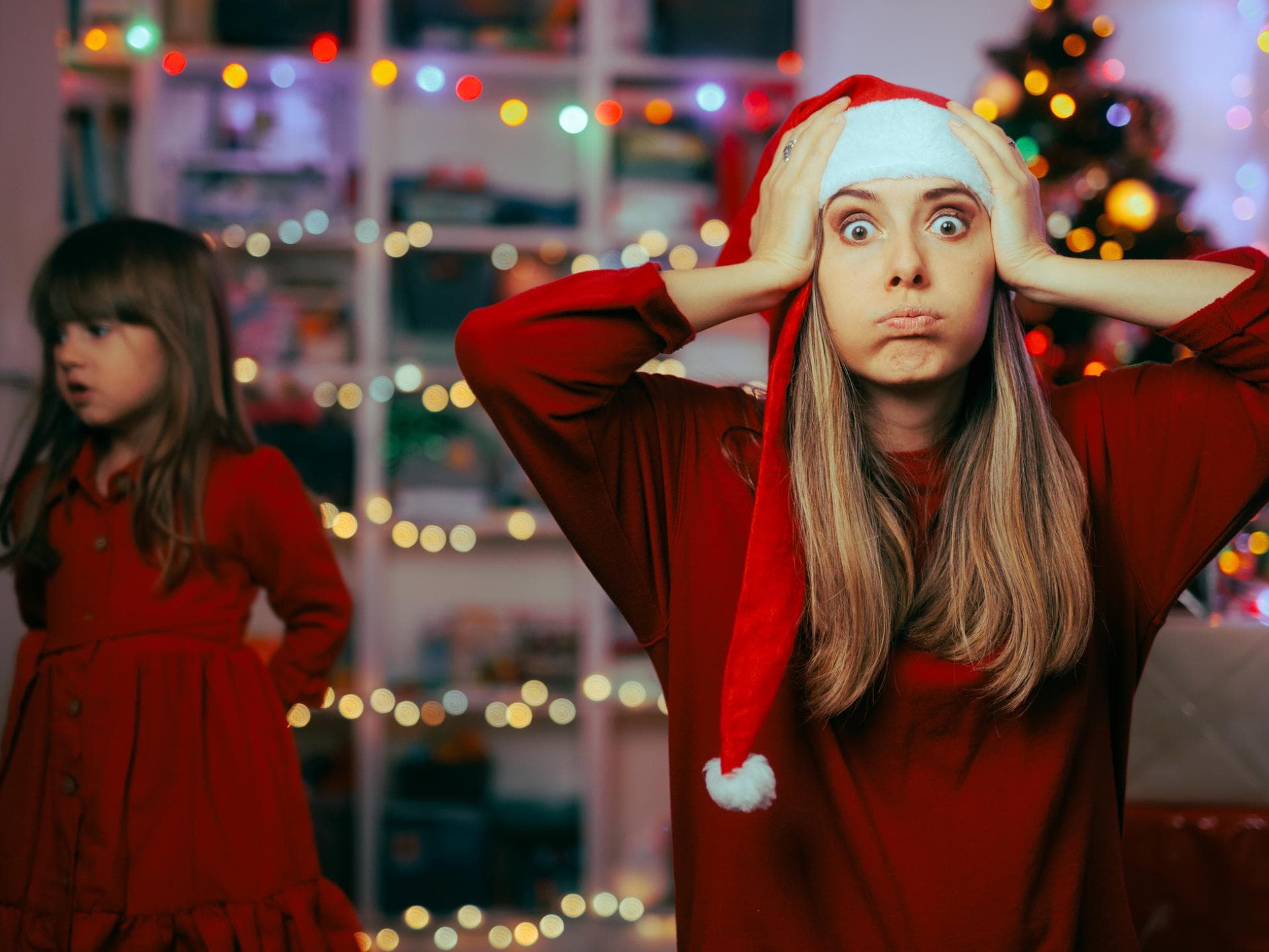 Mutter schlägt an Weihnachten die Hände über dem Kopf zusammen.