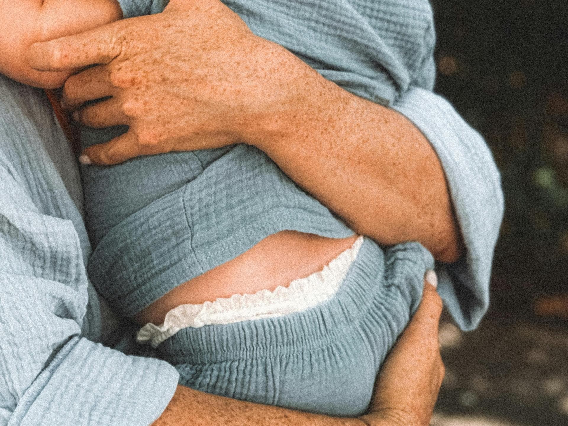 Mutter hält Windelbaby auf dem Arm.