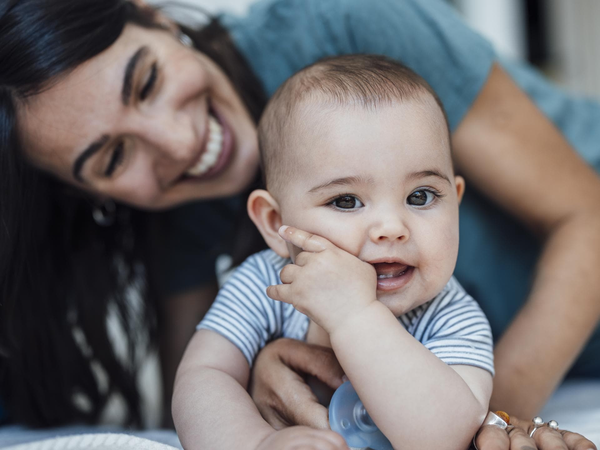 Babys kommunizieren durch nonverbale Signale. Lachendes Baby mit seiner Mutter.