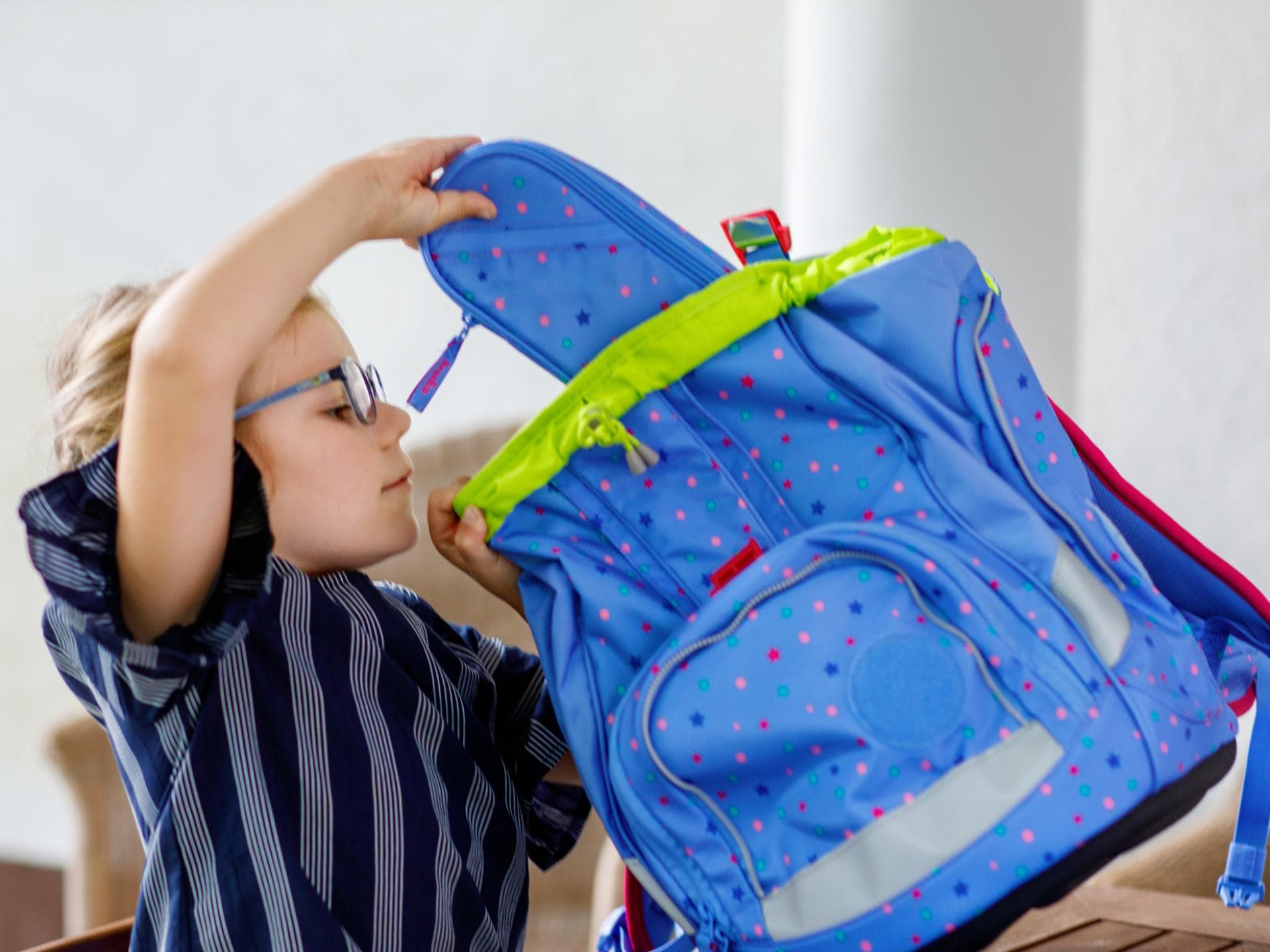 Ein Mädchen packt ihren Schulranzen Ein Mädchen packt ihren Schulranzen
