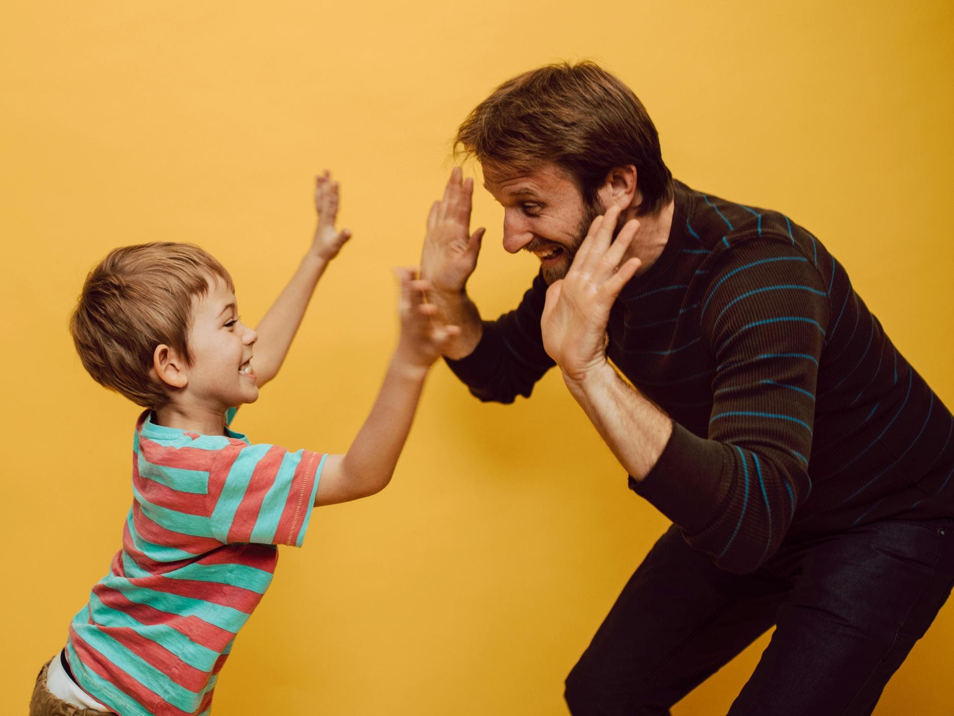 Ein Papa und Sohn klatschen ab.