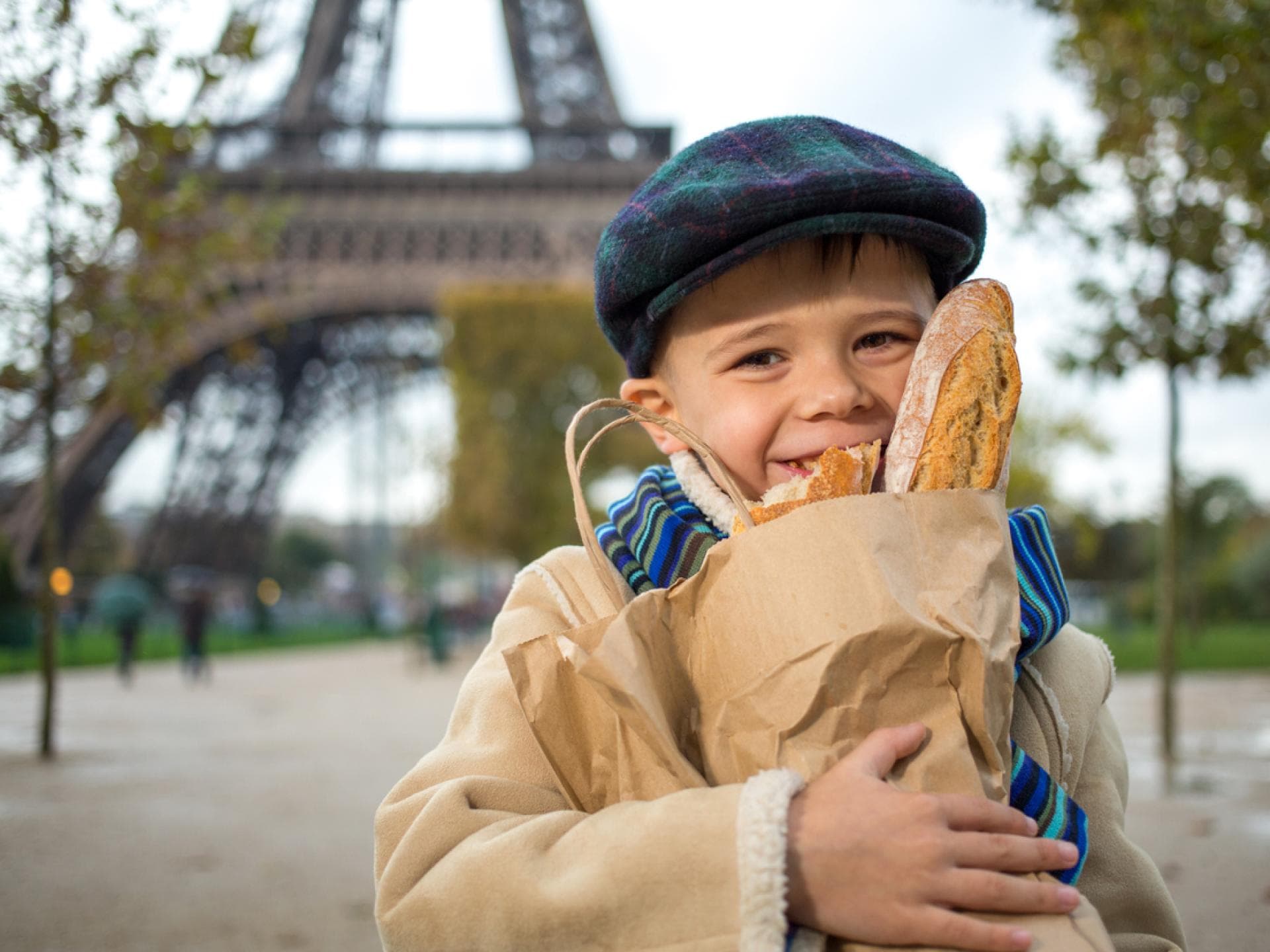Ein Kind in Frankreich mit Baguettes in der Hand