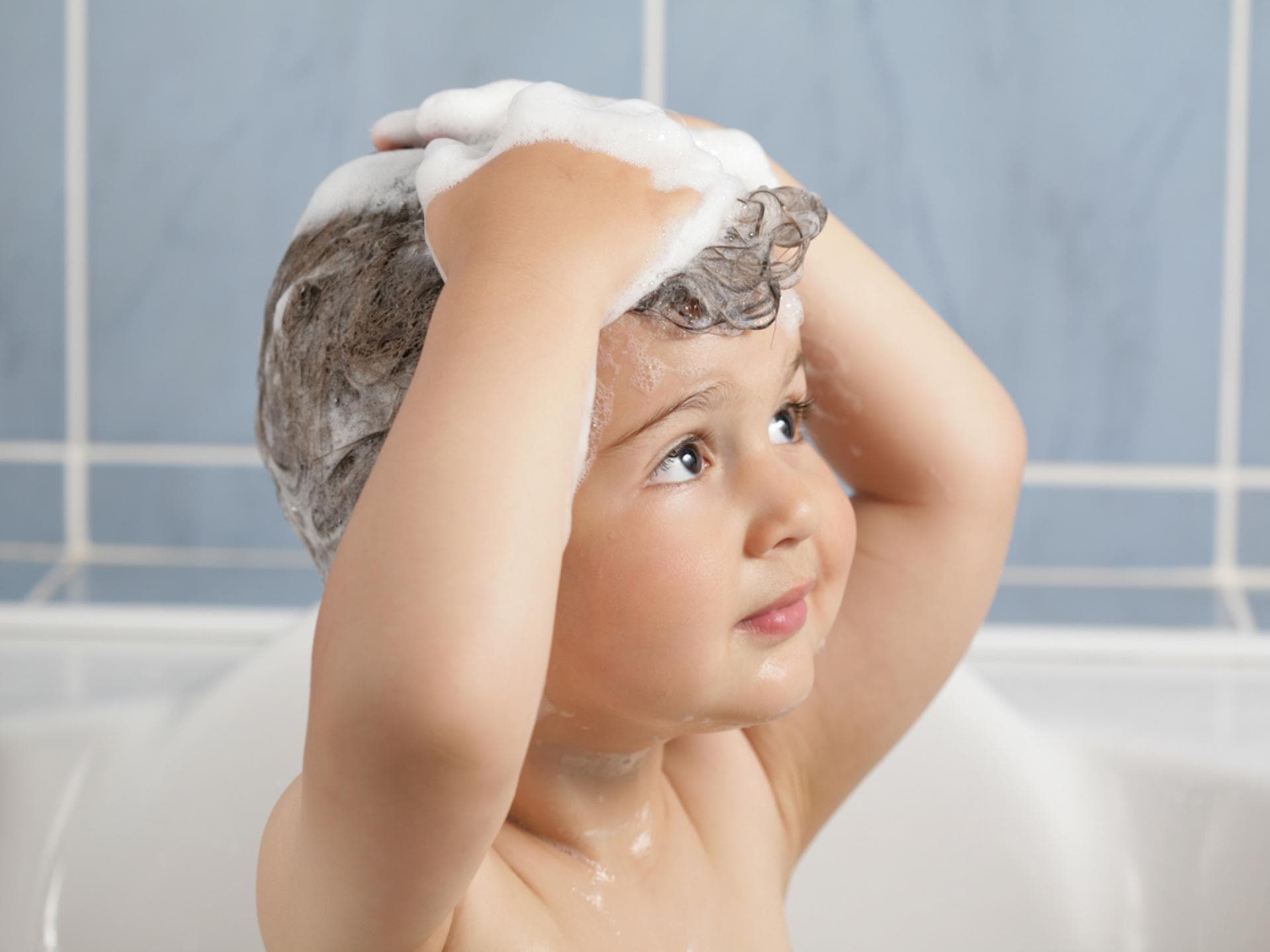 Kleinkind wäscht sich die Haare.