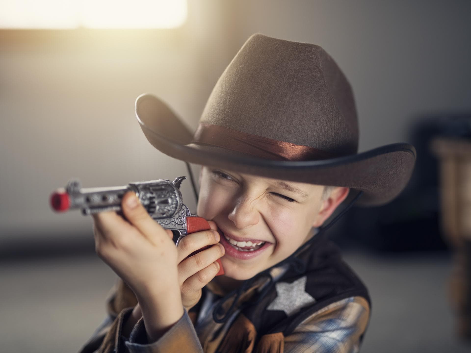Ein Junge als Cowboy mit Spielzeugpistole