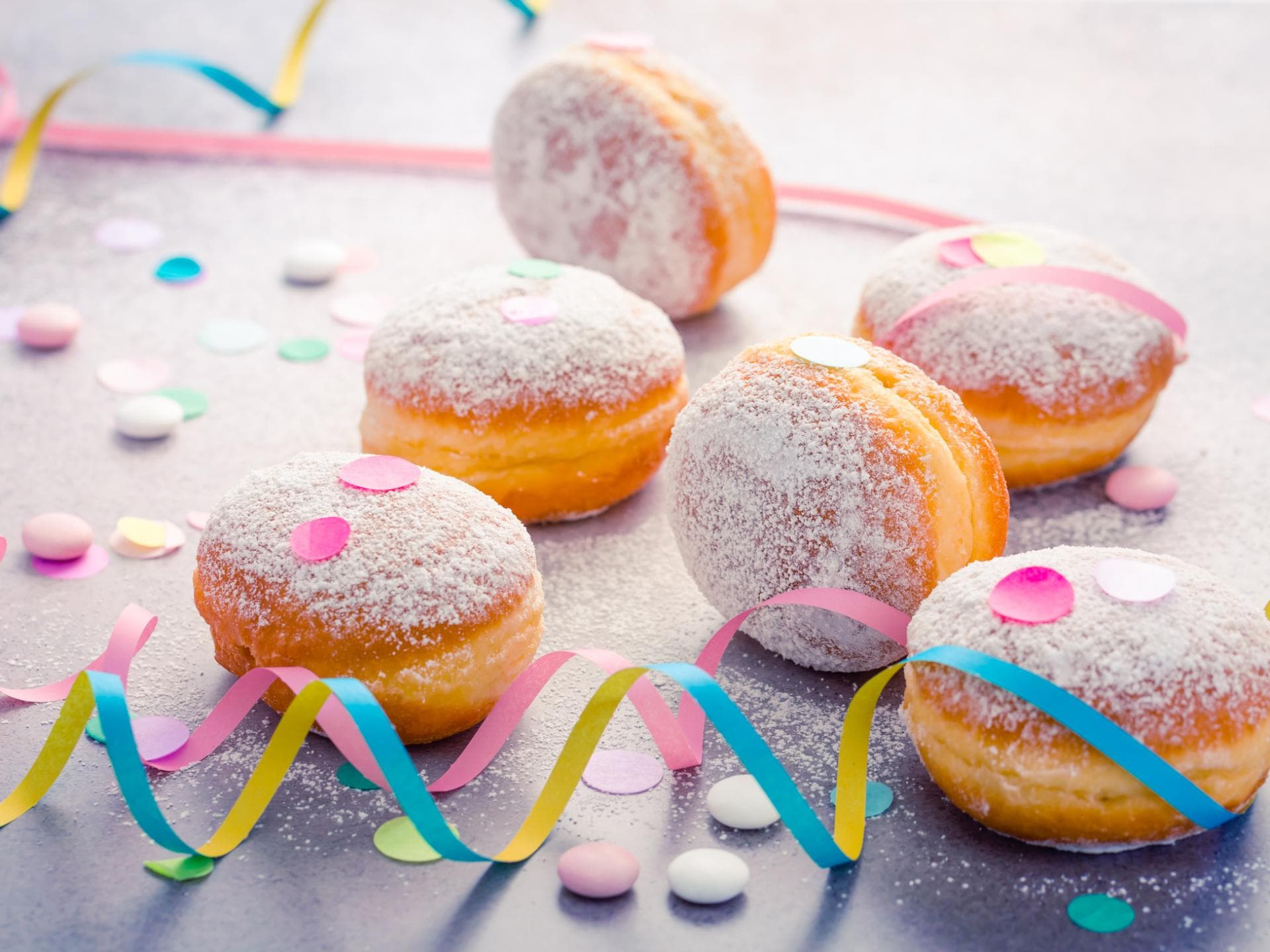 Berliner gehören zu Karneval dazu. Berliner mit Puderzucker, Luftschlangen und Konfetti.
