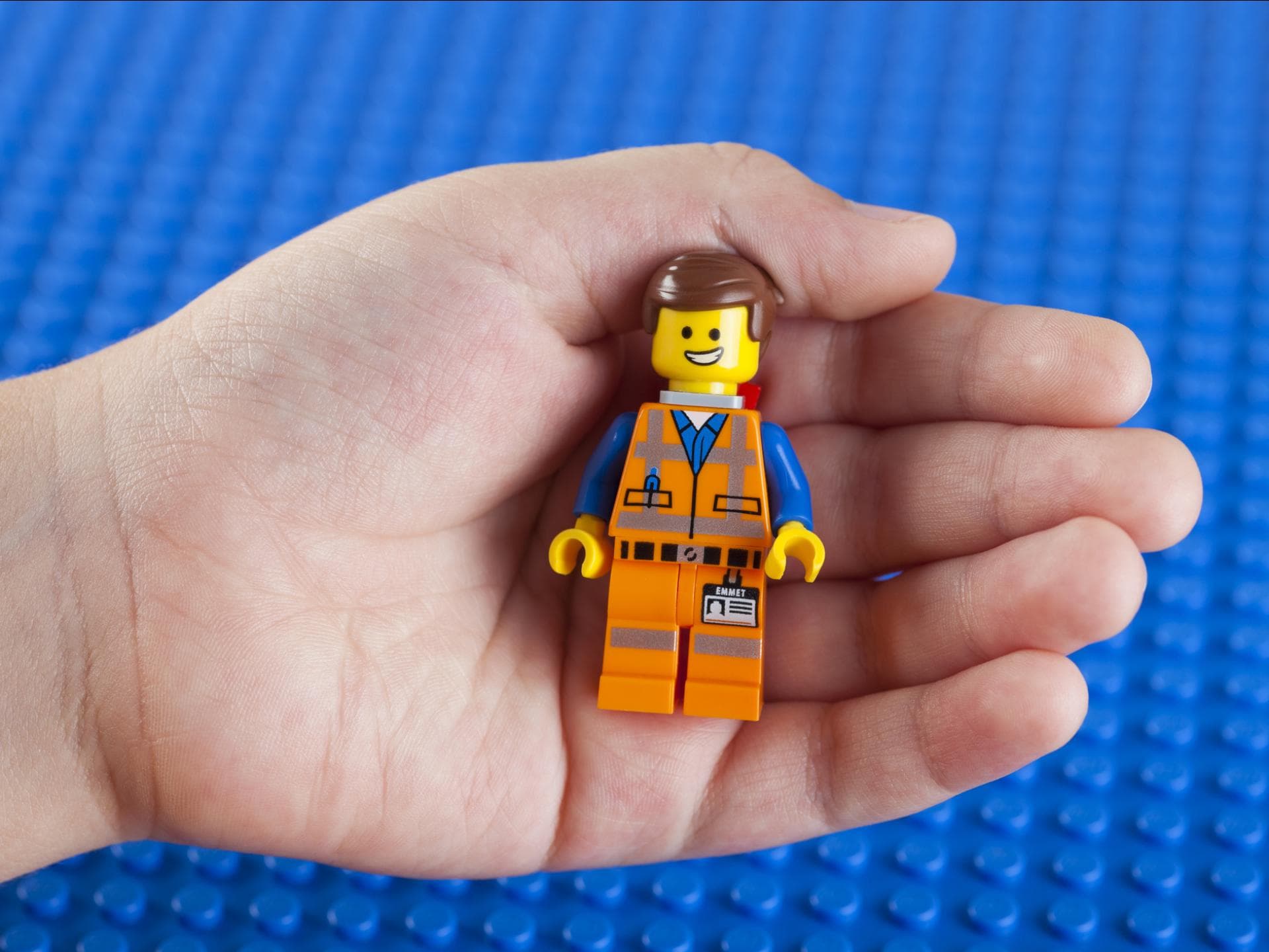 Auch unterwegs kann es Spaß machen, mit Lego zu spielen. Lego-Figur in einer Kinderhand.