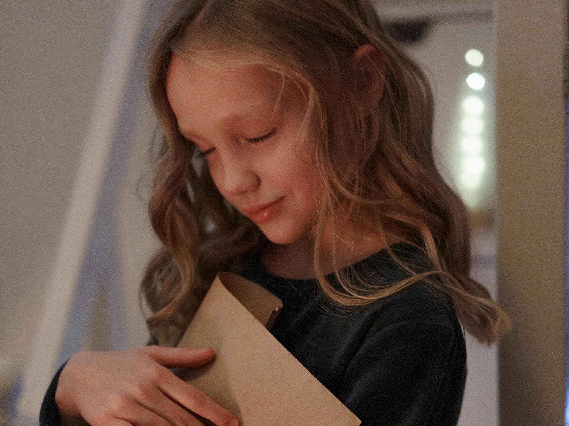 Mädchen hält liebevoll einen Brief in der Hand.