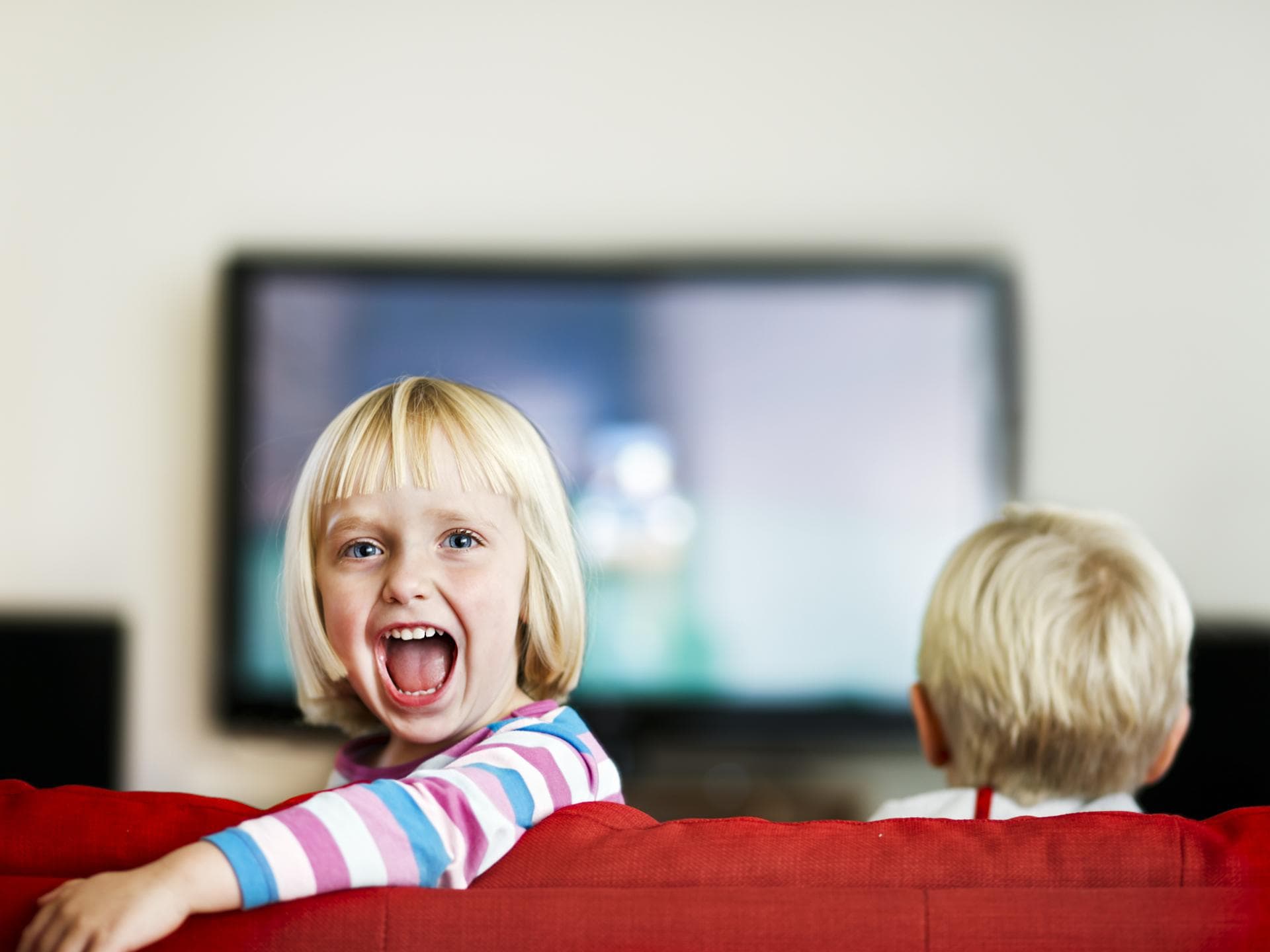 Kinder schauen fernsehen, Mädchen lacht.