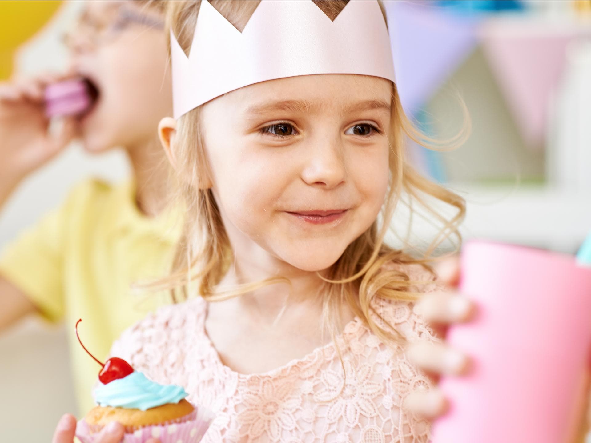 Ist es okay, Trinkgeld für den Kindergeburtstag zu verlangen? Kleines Mädchen mit Geburtstagskrone.