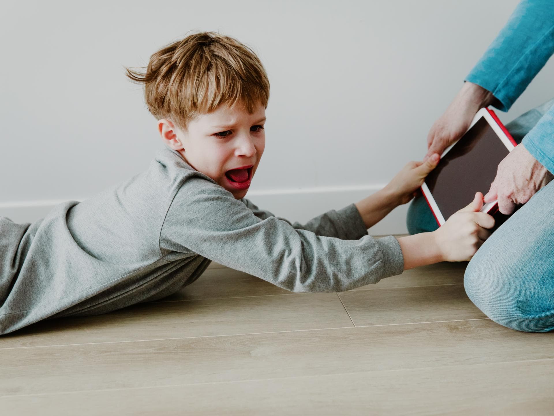 Junge hält schreiend das Tablet fest.
