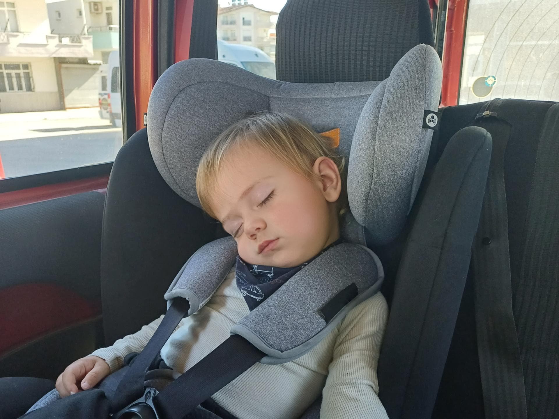 Ein Kleinkind schläft im Auto ein. 