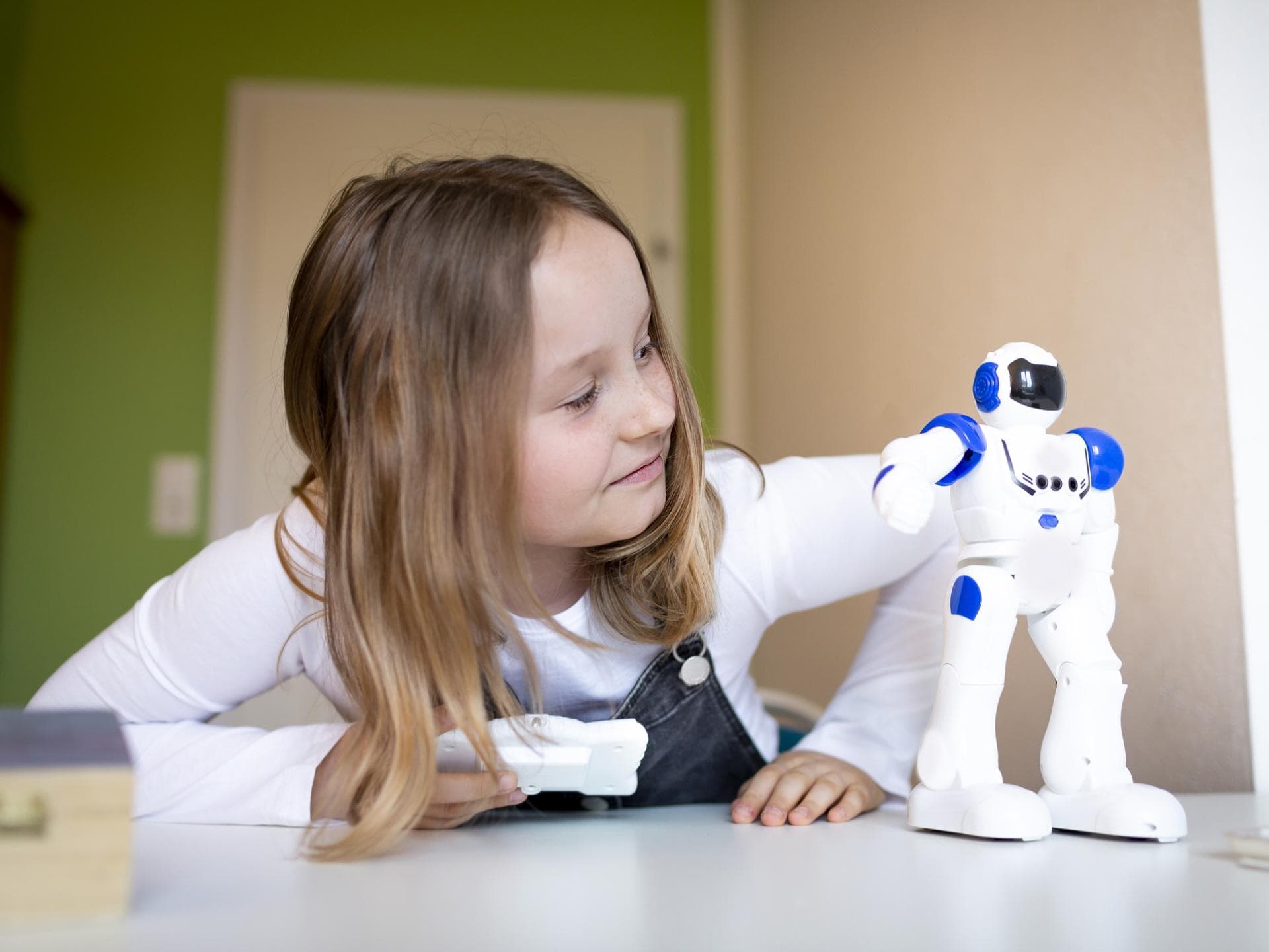 Smart Toys können gefährlich werden – wenn man sie missbraucht. Mädchen spielt mit kleinem Roboter.