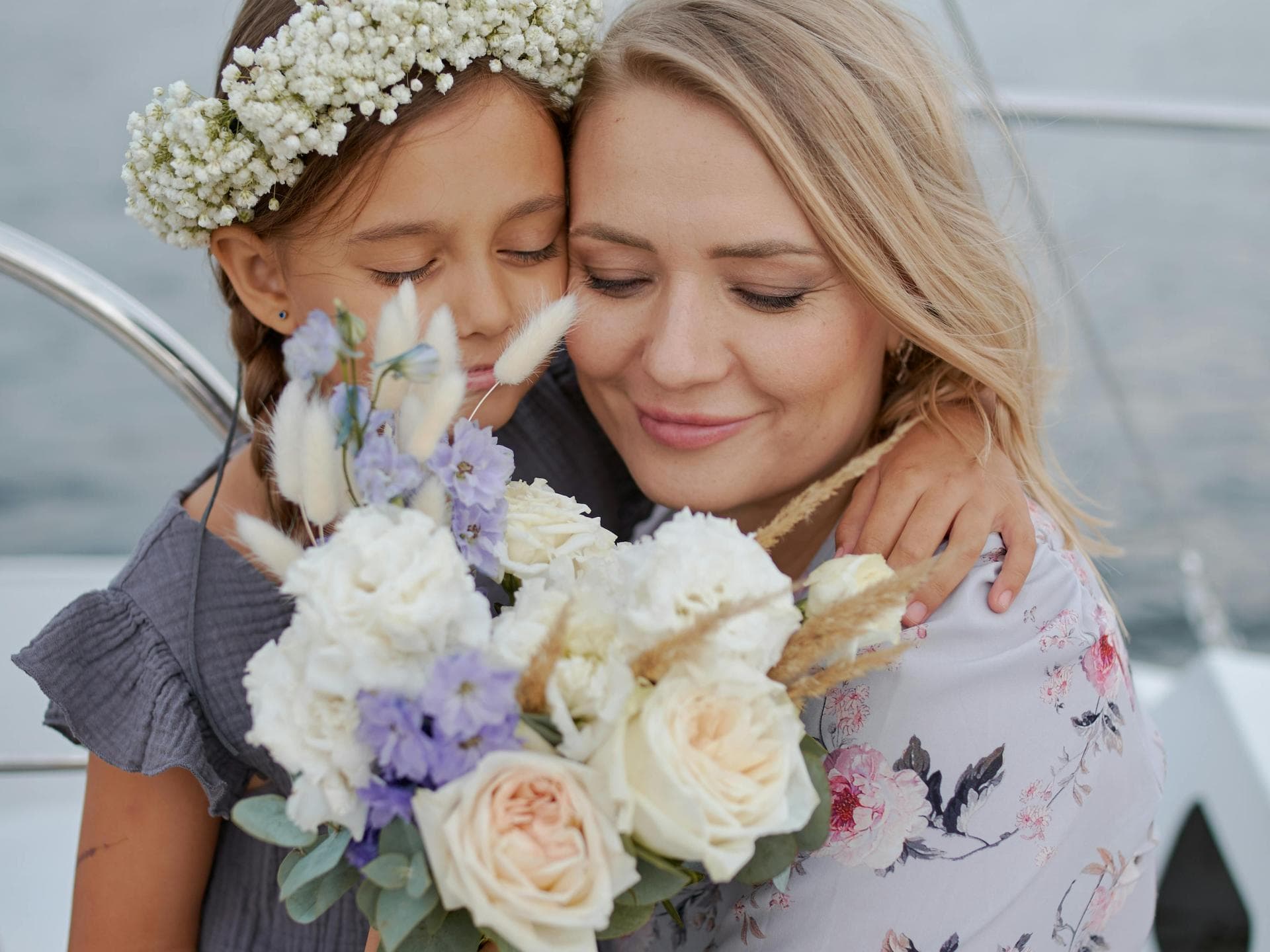 Welche Blumen schenkt man zum Muttertag? Ein Mädchen schenkt seiner Mutter Blumen zum Muttertag.
