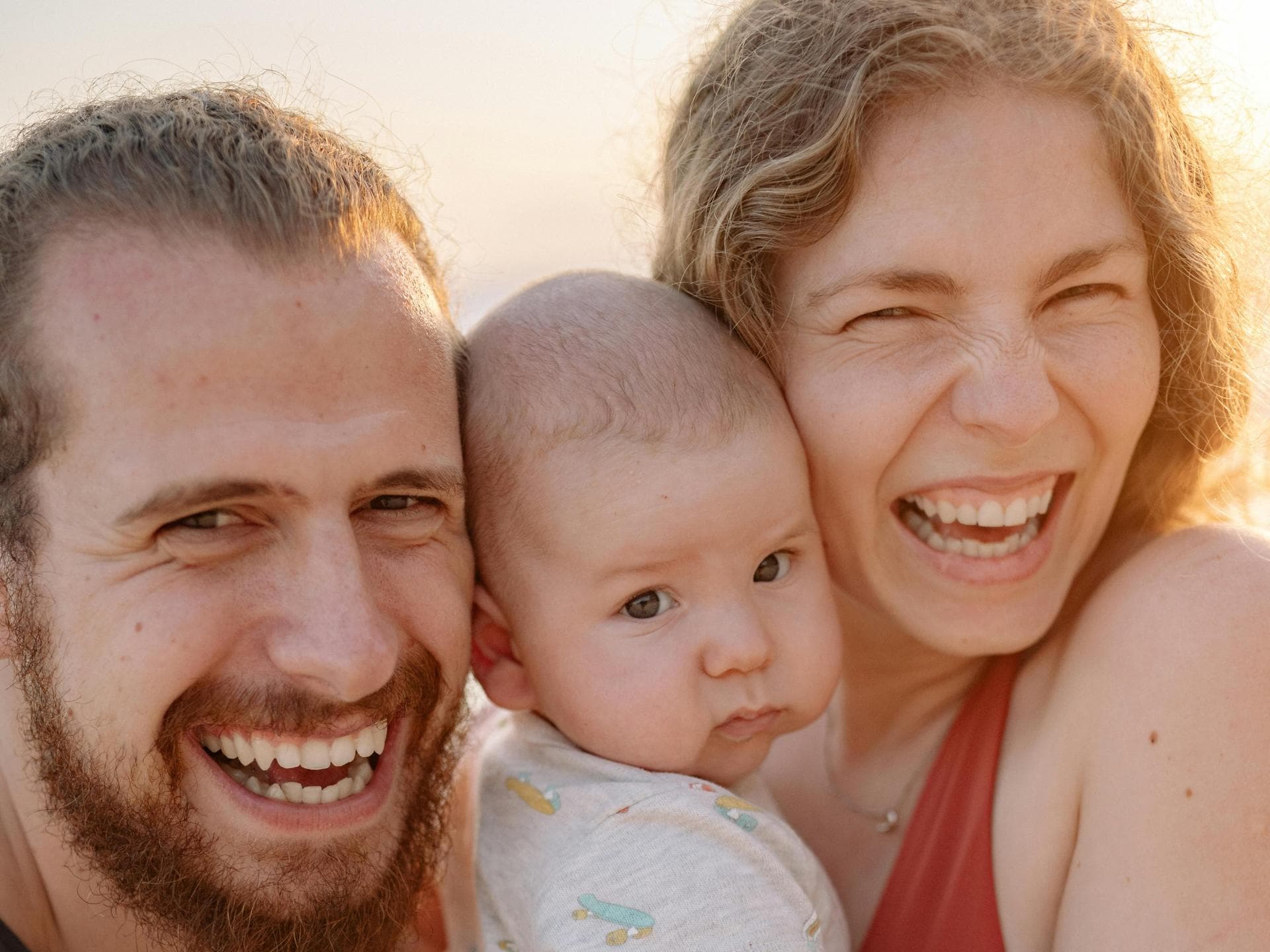 Eltern haben ihre eigene Sprache. Eltern lachen mit Baby auf dem Arm.