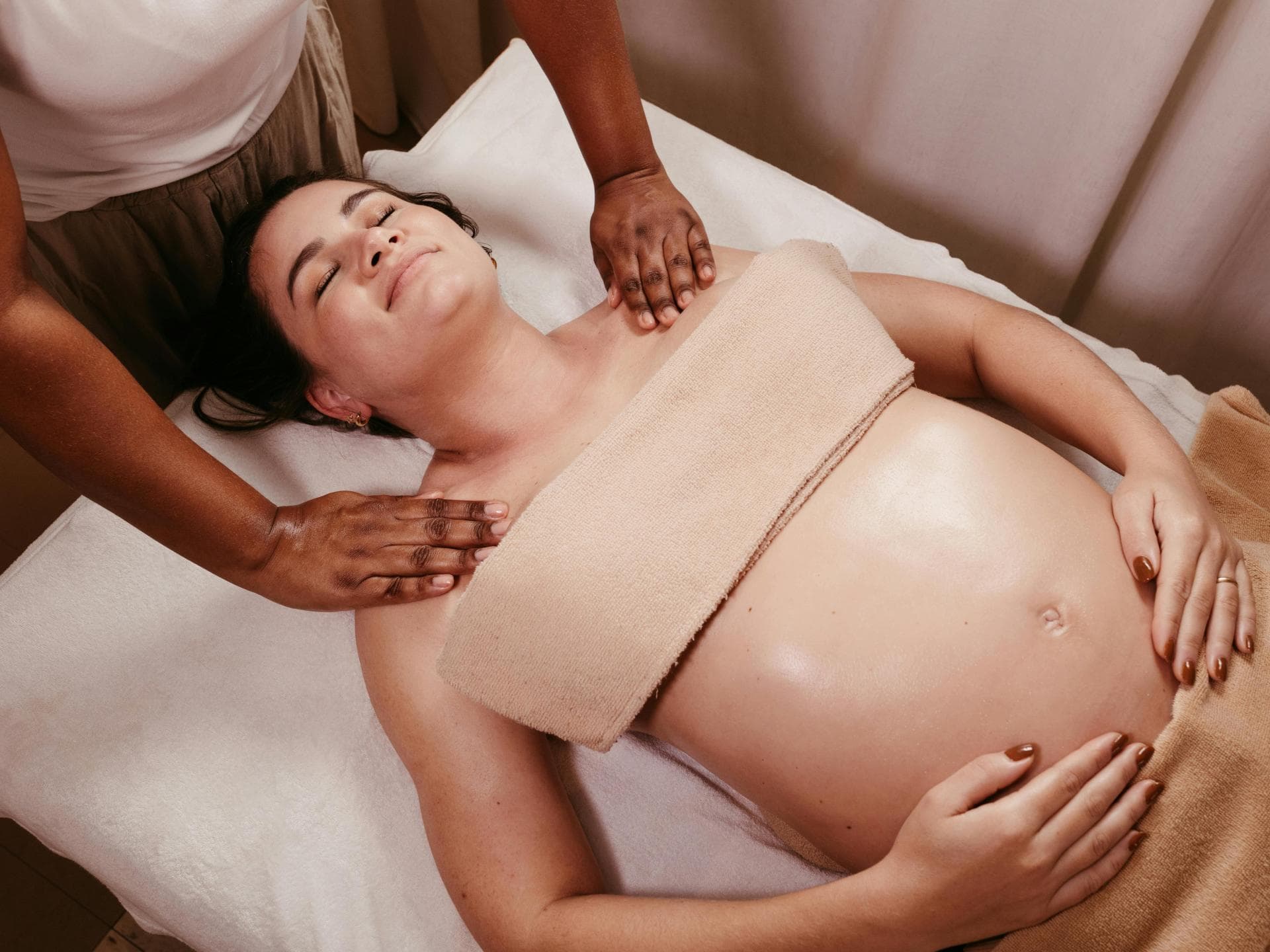 Eine Schwangerschaftsmassage kann sehr wohltuend sein. Schwangere wird massiert.