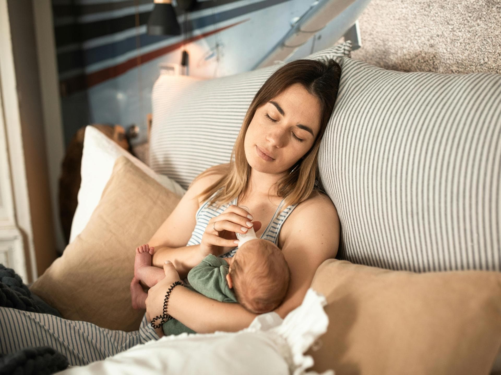 Müde Mama füttert ihr Baby mit der Flasche.
