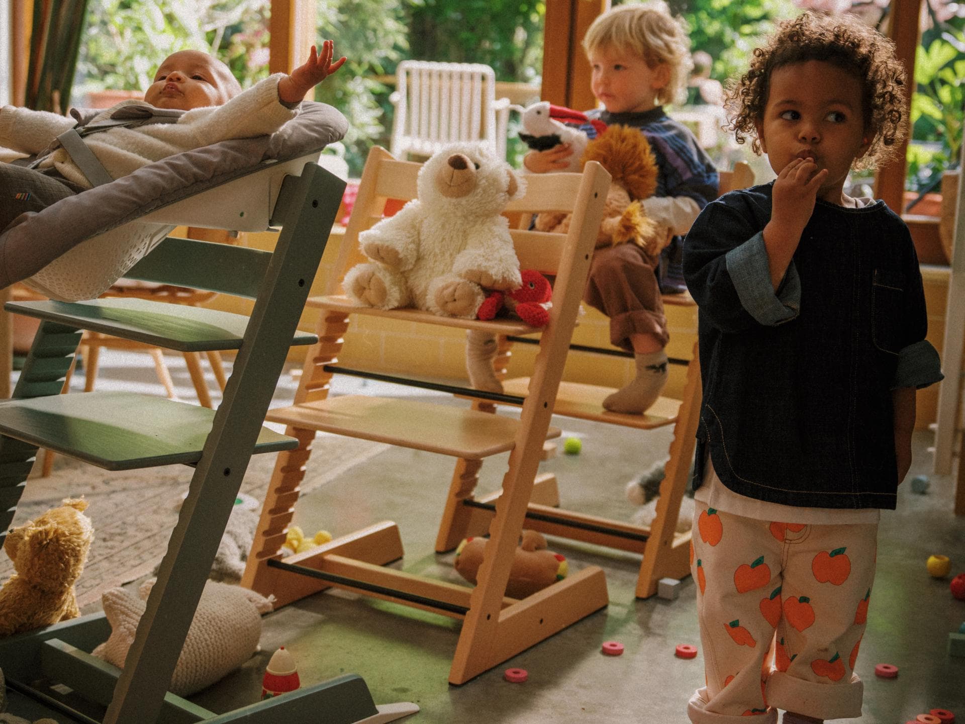 Baby und zwei Kinder spielen mit Tripp Trapp-Stühlen Zug. Baby und zwei Kinder spielen mit Tripp Trapp-Stühlen Zug.