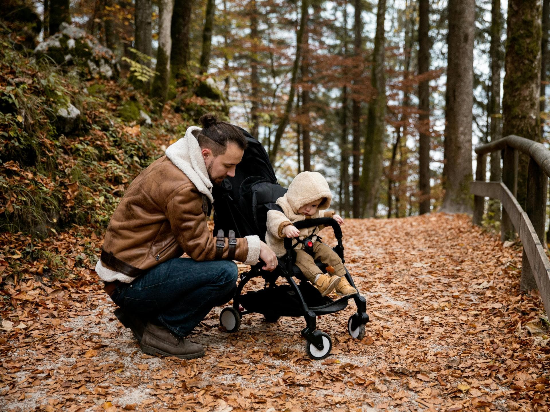 Viele Kinder wollen ihre Eltern vom Buggy aus sehen. Vater mit Kind im Herbstwald.