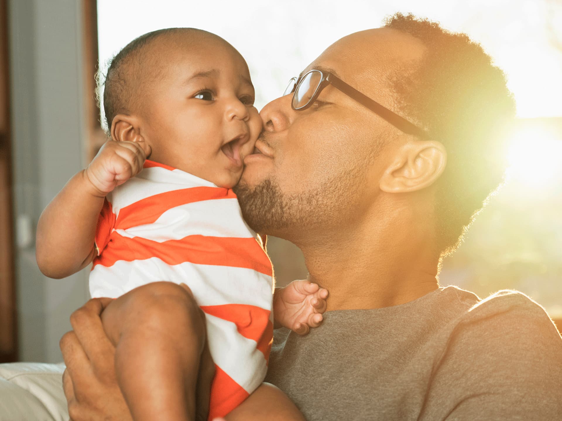 Ein Vater küsst sein Baby. 