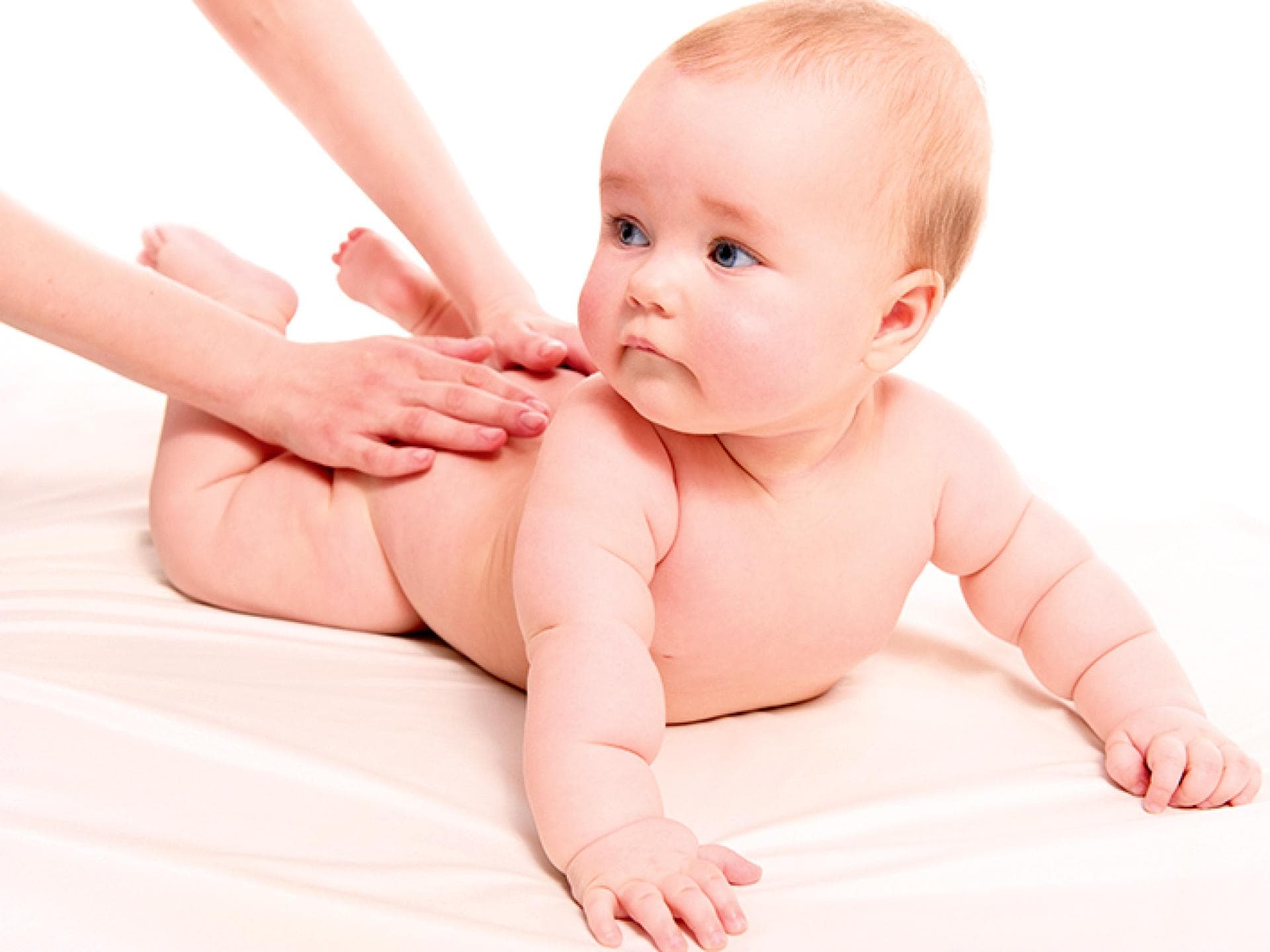 Ein Baby wird am Rücken massiert. 