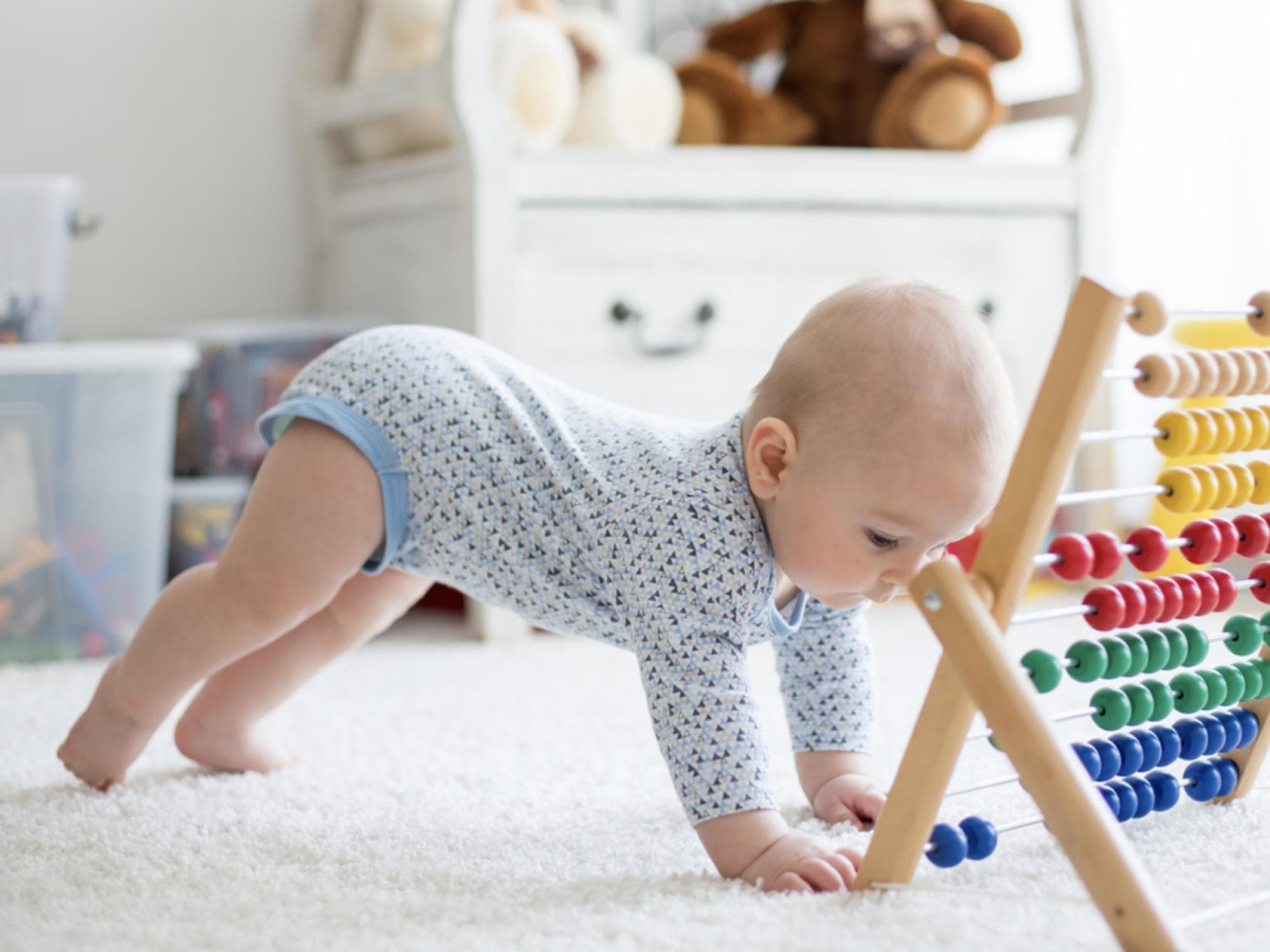 Bestimmte Lebensmittel sollen sich positiv auf die Gehirnentwicklung von Babys auswirken. Ein kleines Baby spielt mit einem Rechenschieber.