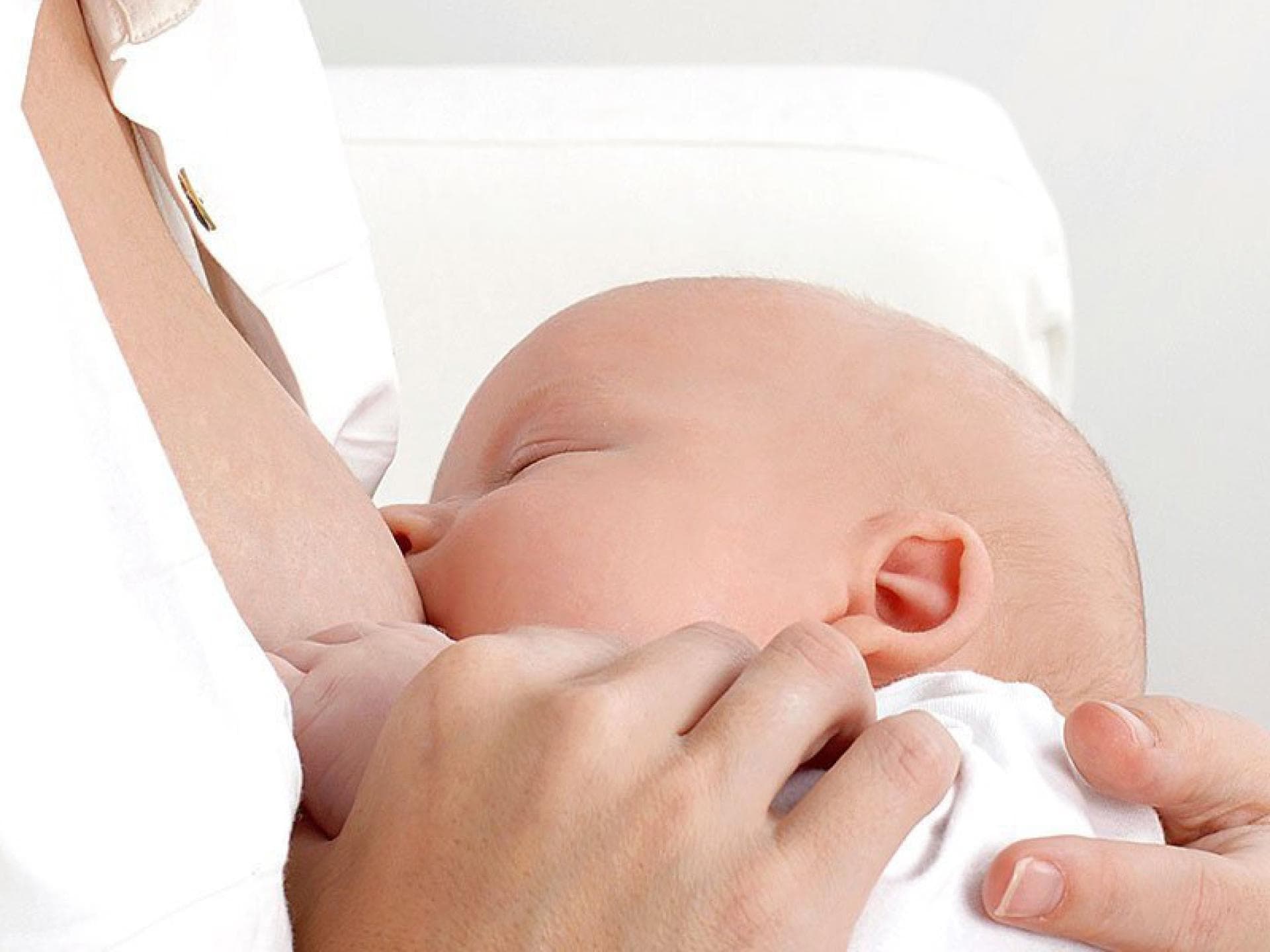 Silberhütchen können bei entzündeten Brustwarzen sehr gut helfen. Baby trinkt an der Brust.