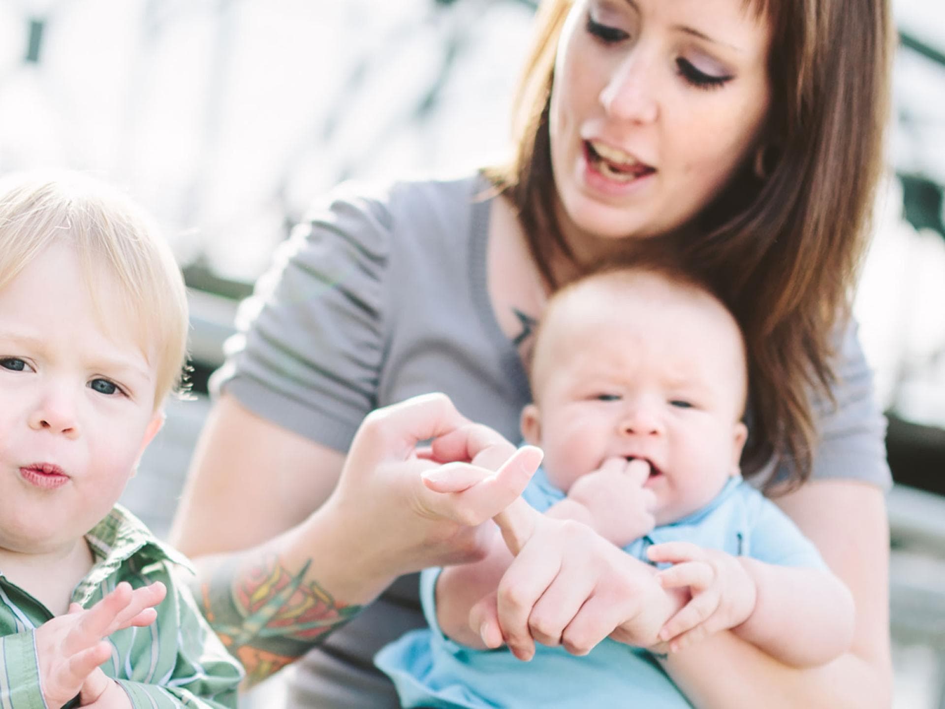 Schon vor dem Sprechenlernen können Eltern und Kinder mit der Zeichensprache kommunizieren. Mutter übt mit Baby und Kleinkind die Babyzeichensprache.