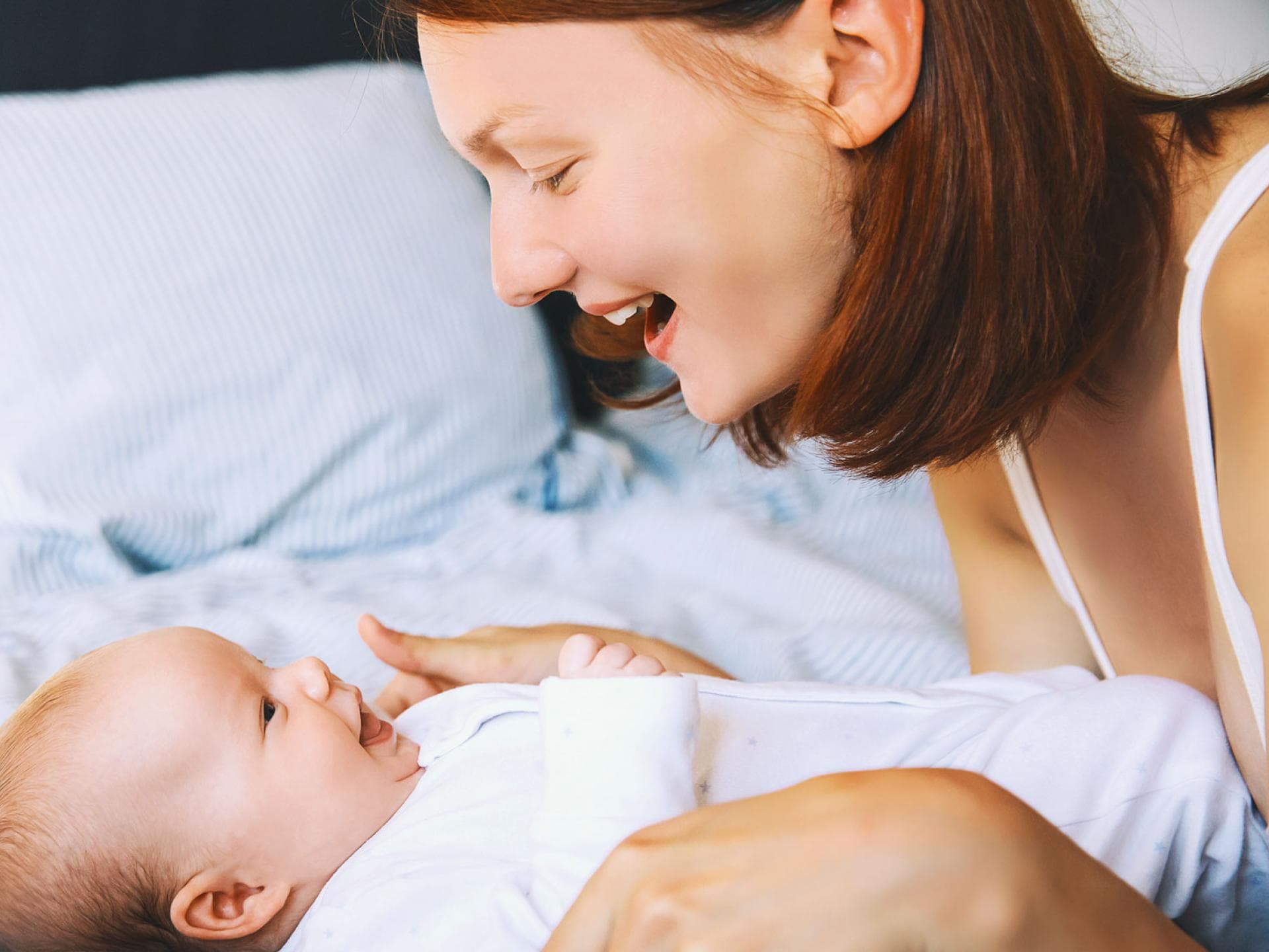 Eine Frau lächelt ihr Baby an. 