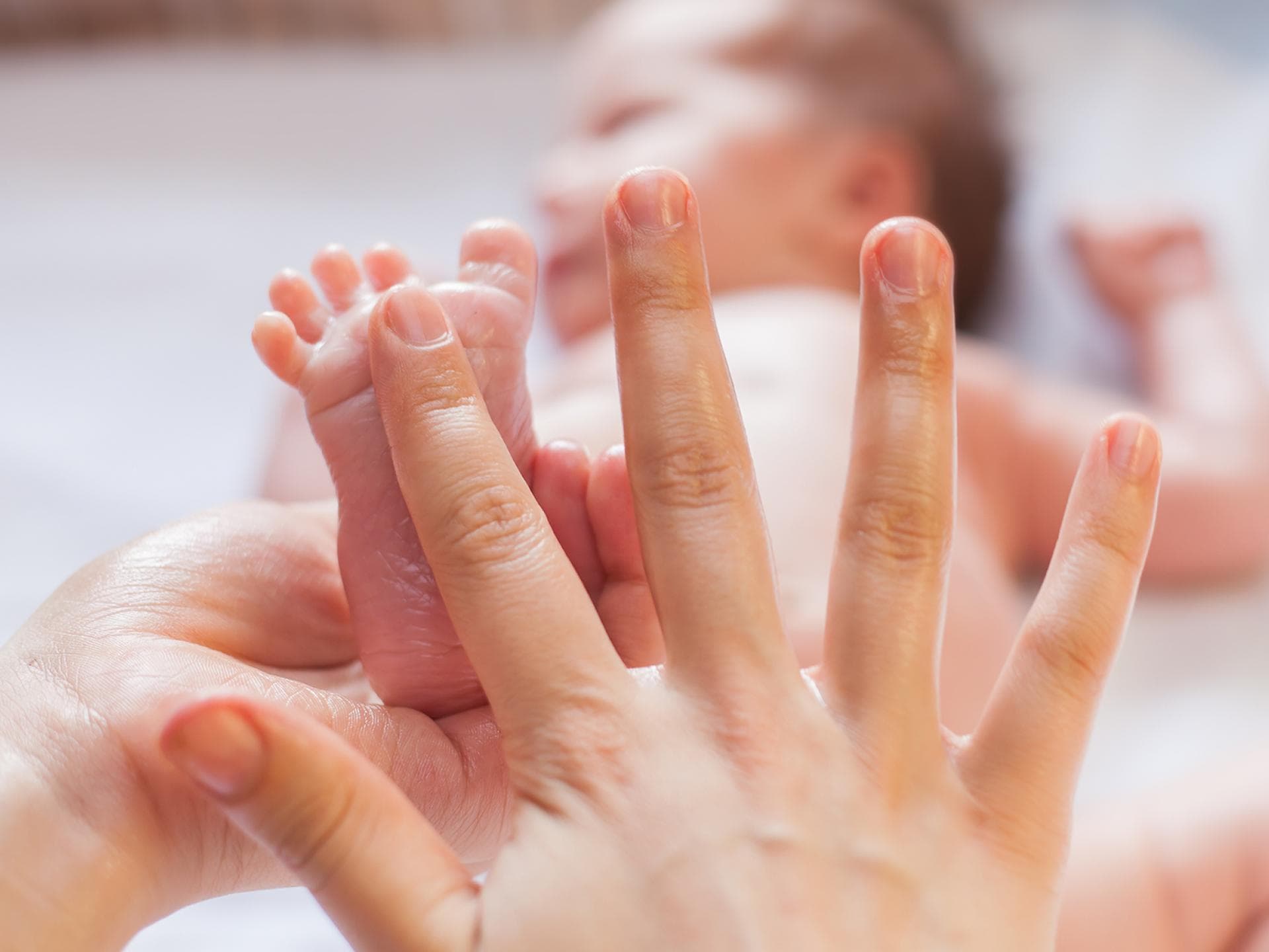Mutter gibt Öl auf Babyfuß.