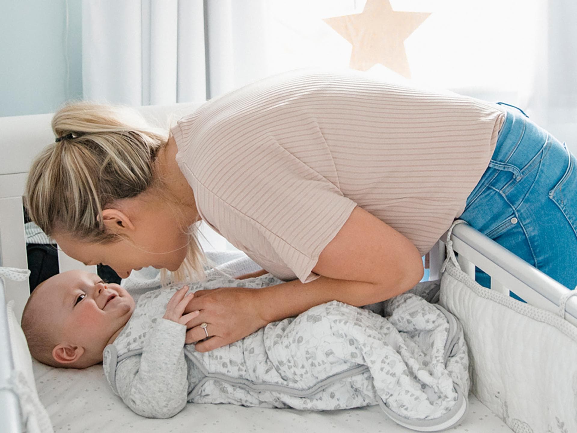 Eine Mama bringt ihr Baby ins Bett.