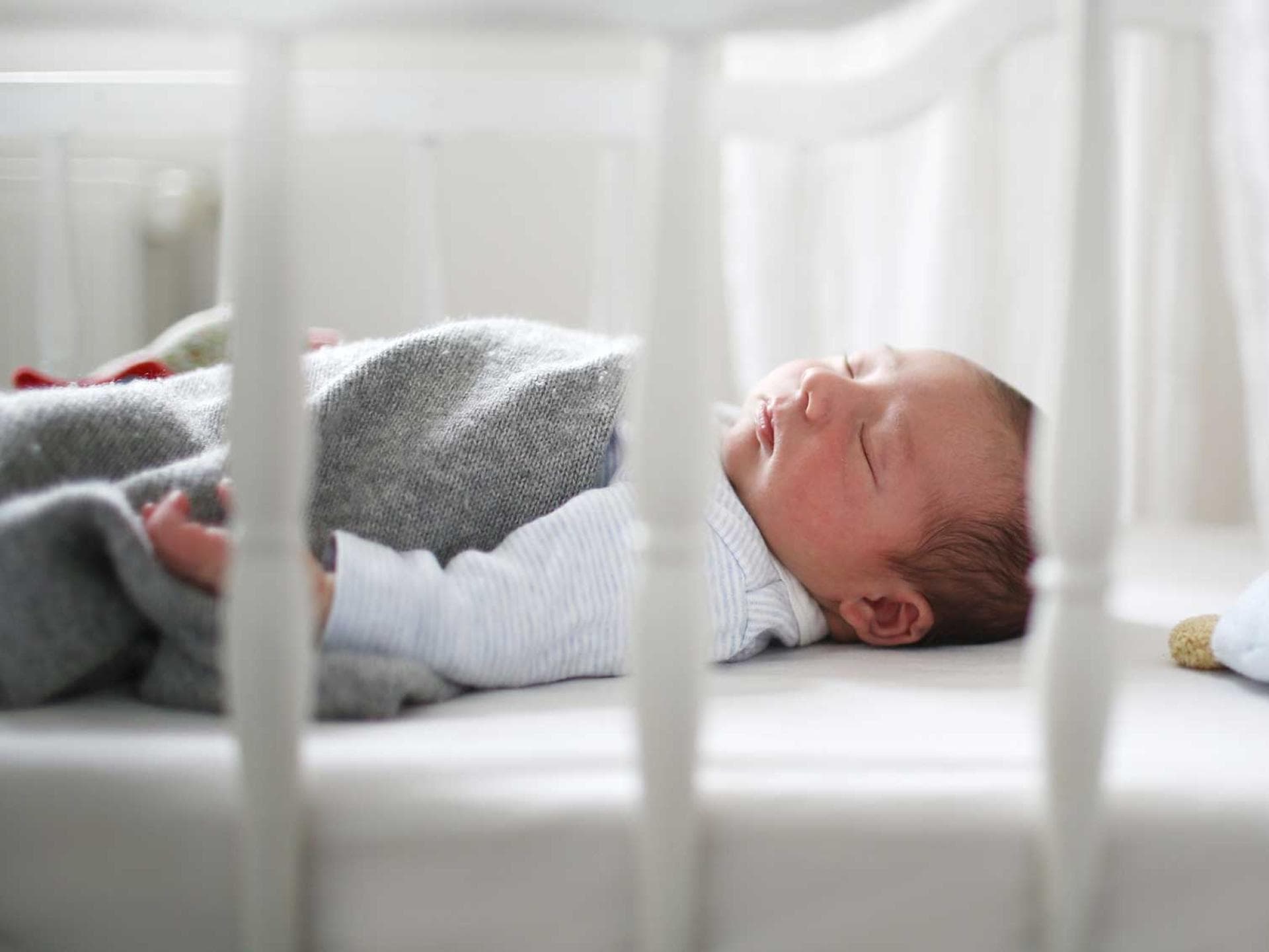 Babymatratzen werden zum Glück sicherer. Baby schläft im Bettchen.