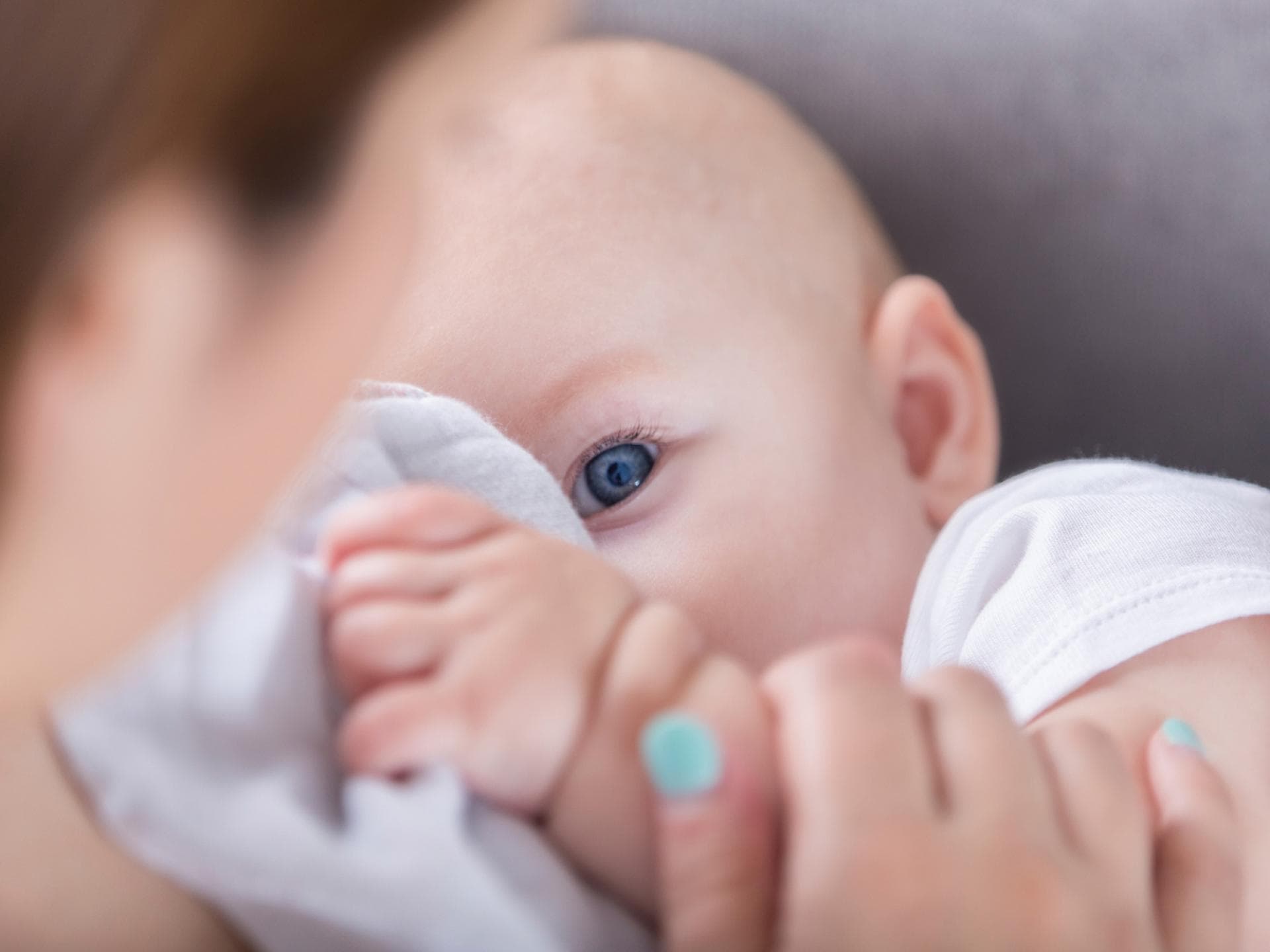 Baby mit Schnuffeltuch auf Mamas Arm.