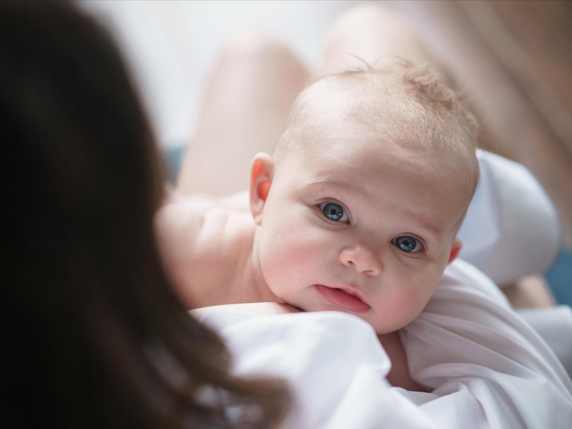 Kleines Baby schaut nach dem Stillen hoch.