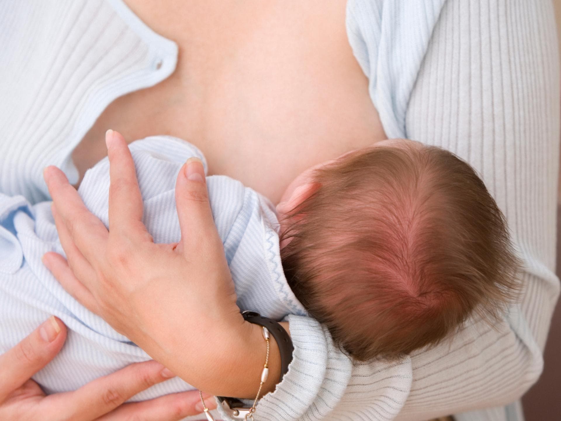 Frau hält Baby beim Stillen 