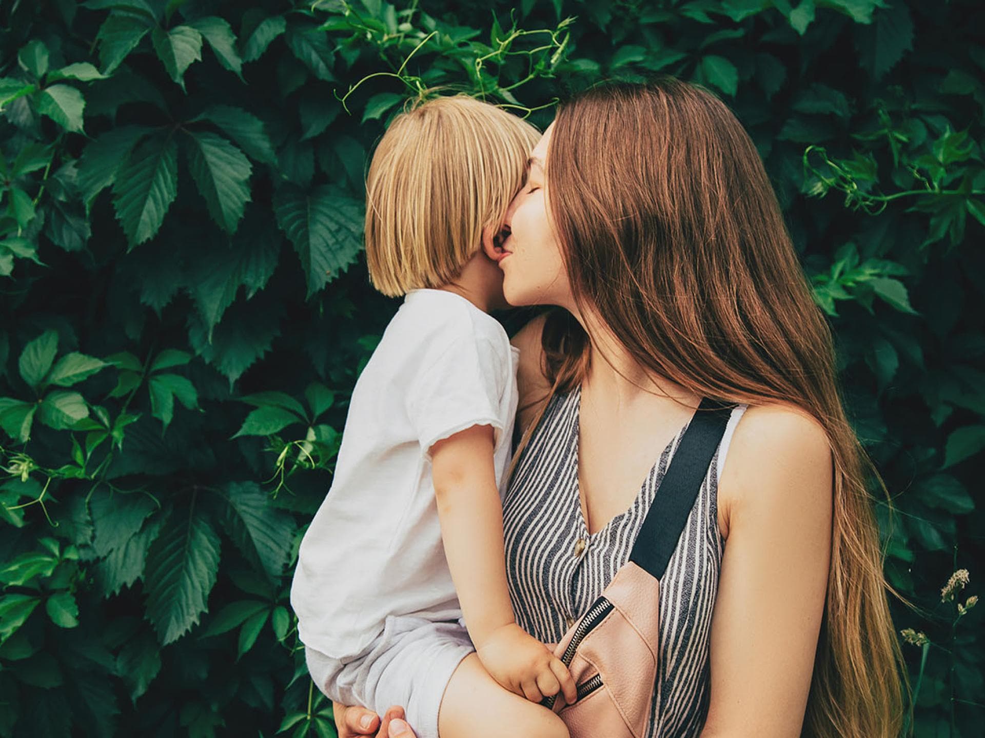 "Du bist meine allerliebste Mama!", Sätze die man im ganzen Alltagsstress schnell mal überhören kann, sagt Bloggerin Marina. Mama küsst Ohr ihres Kindes.