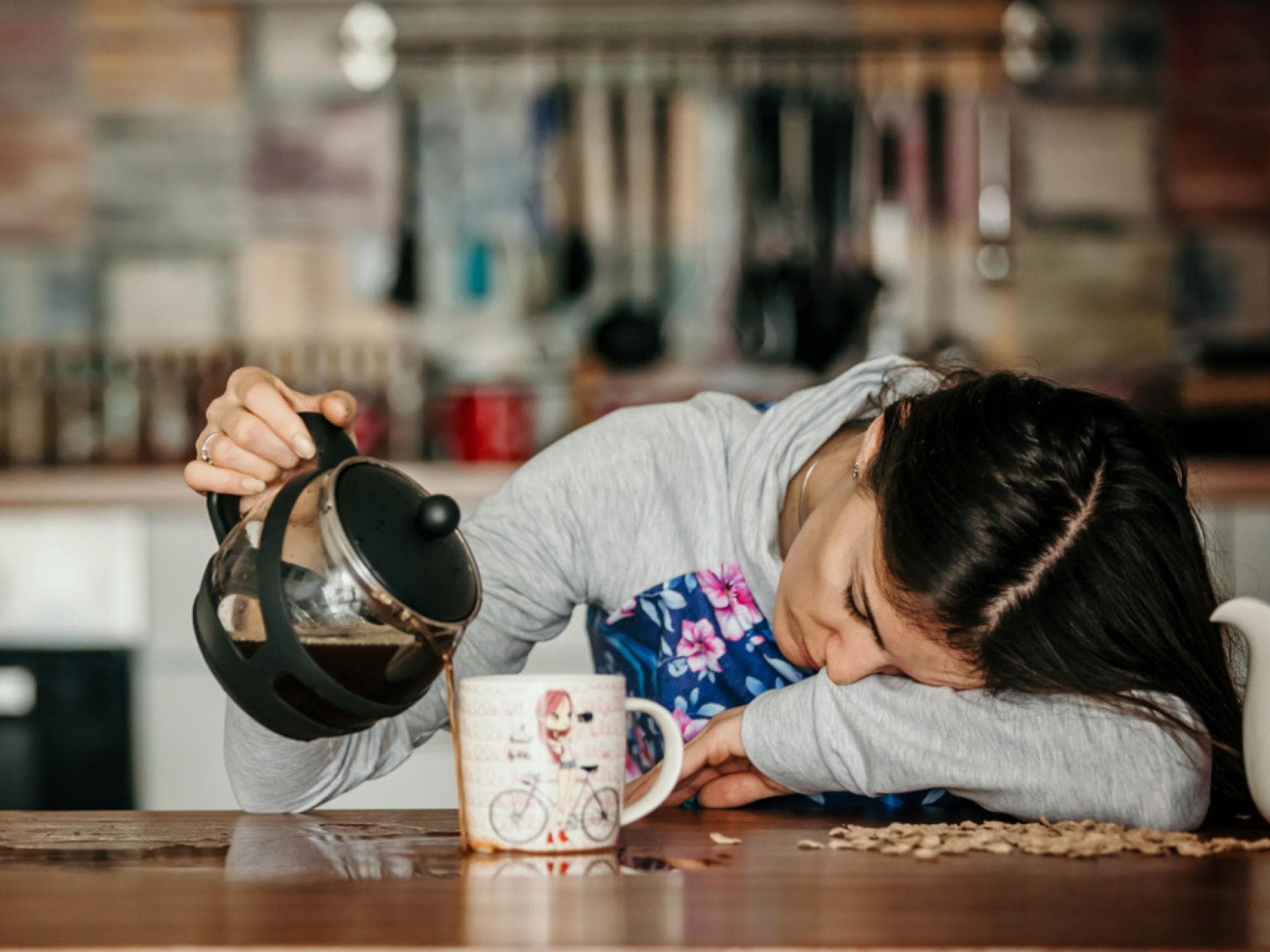 Müde Mama verschüttet Kaffee.
