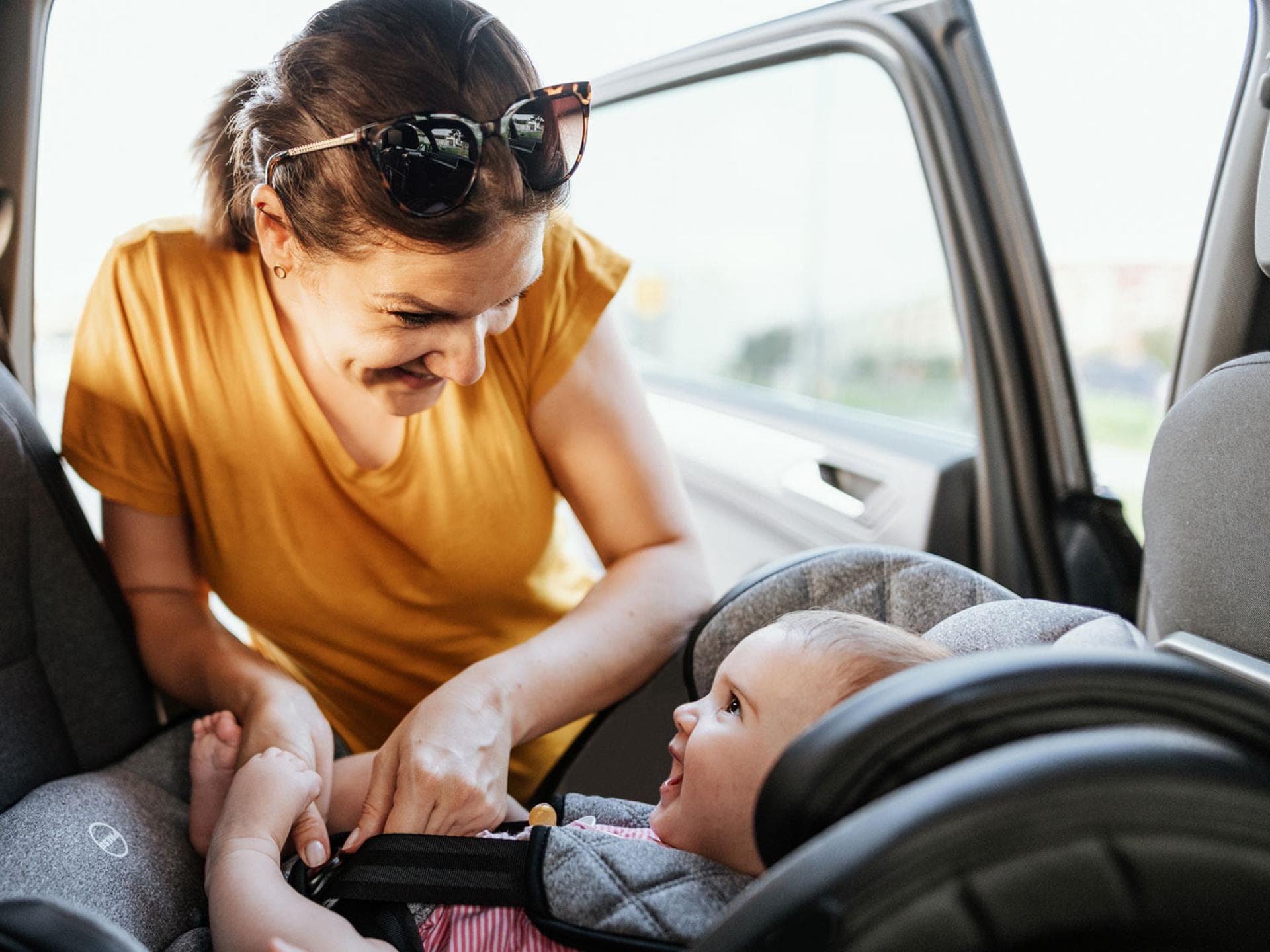 Eine Mutter schnallt ihr Baby im Auto an.