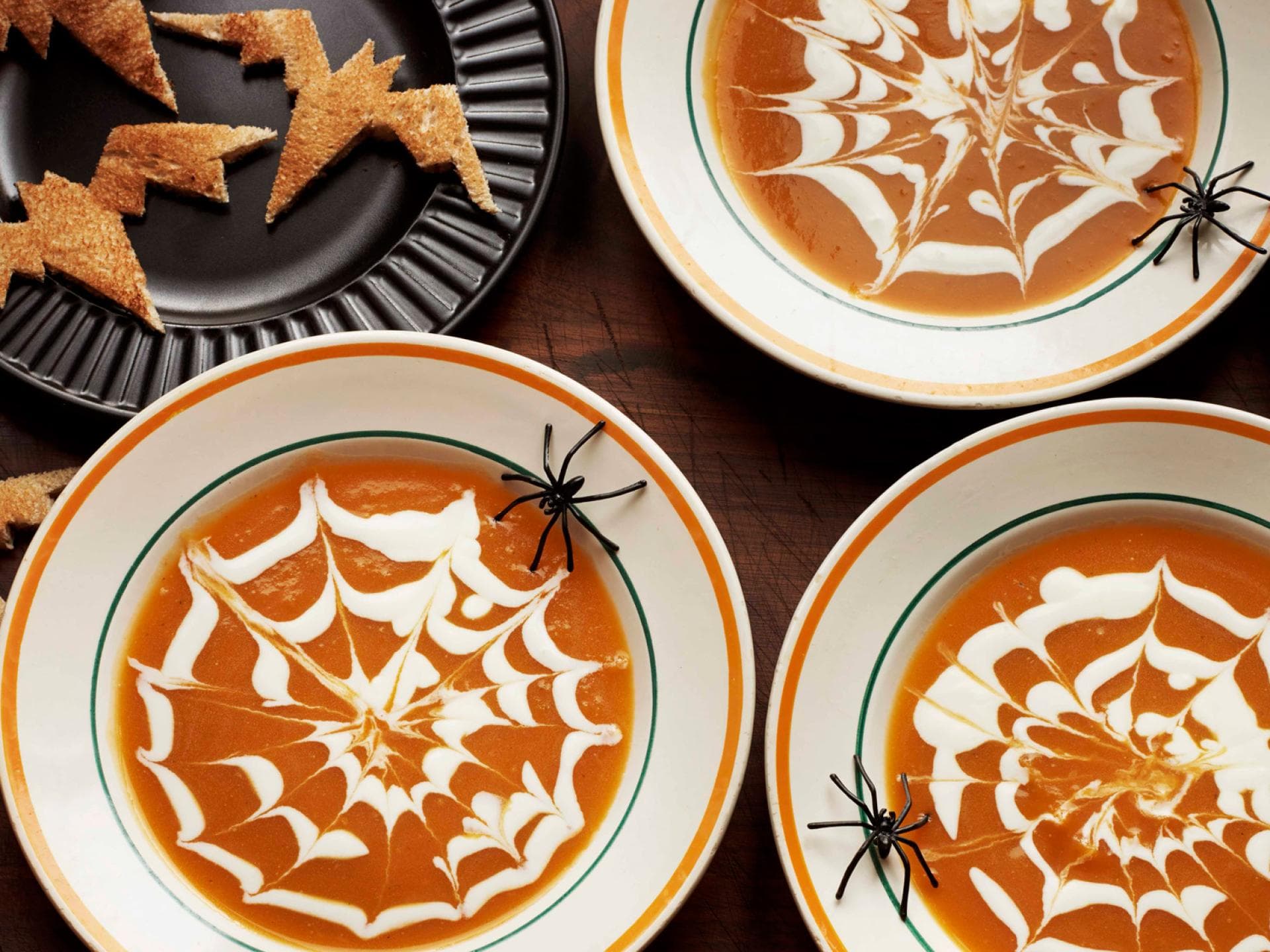 Halloween-Kürbissuppe mit Spinnennetzmuster.