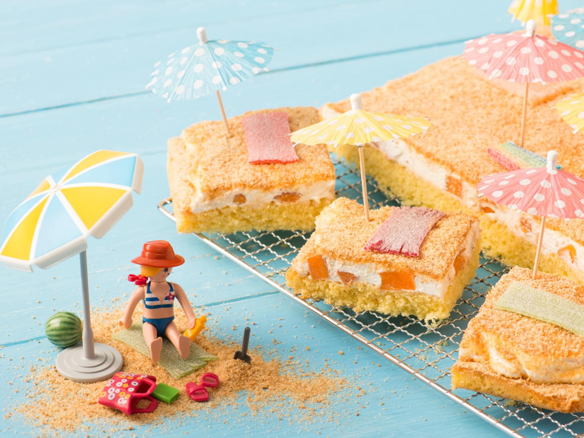Ein sommerlicher Fantakuchen ist mit Deko-Schirmchen dekoriert.