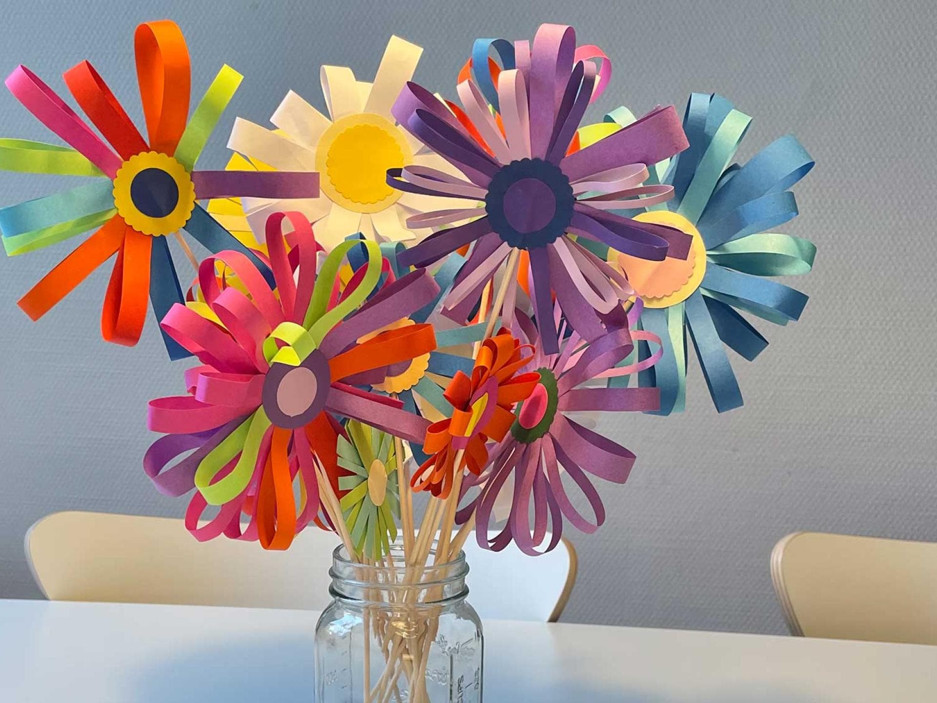 Die versprühen gute Laune: selbst gebastelte Papierblumen auf dem Küchentisch. Ein Strauß selbst gebastelter Papierblumen